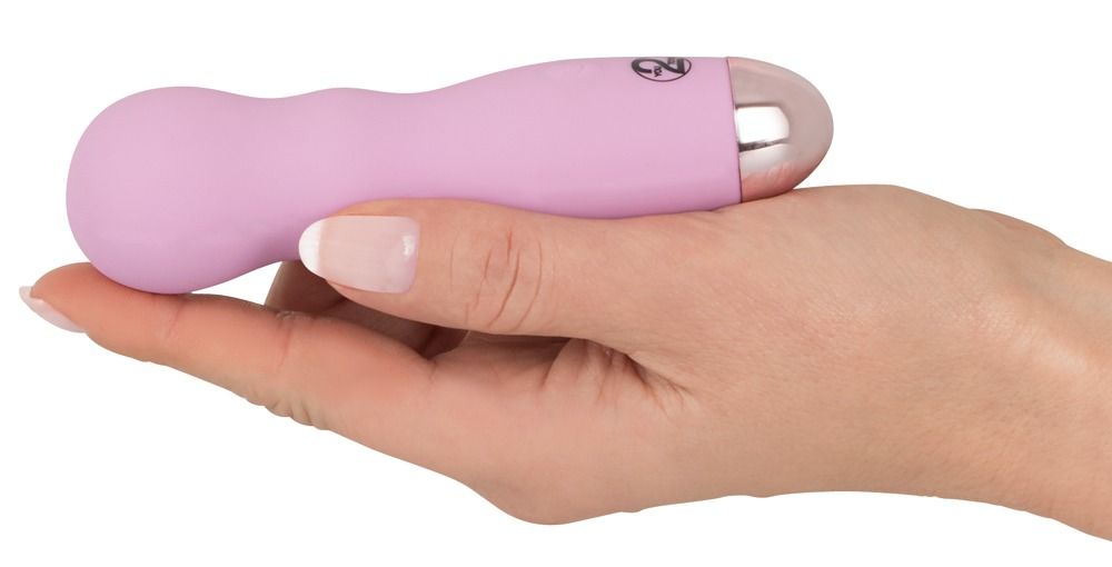 Rosa Mini-Vibrator in einer Hand gehalten, von der Seite betrachtet.