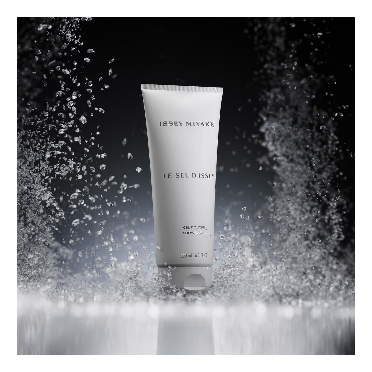 Weißer Tubenbehälter vor dunklem Hintergrund mit Wasserspritzern. Produktname und Marke sind sichtbar.