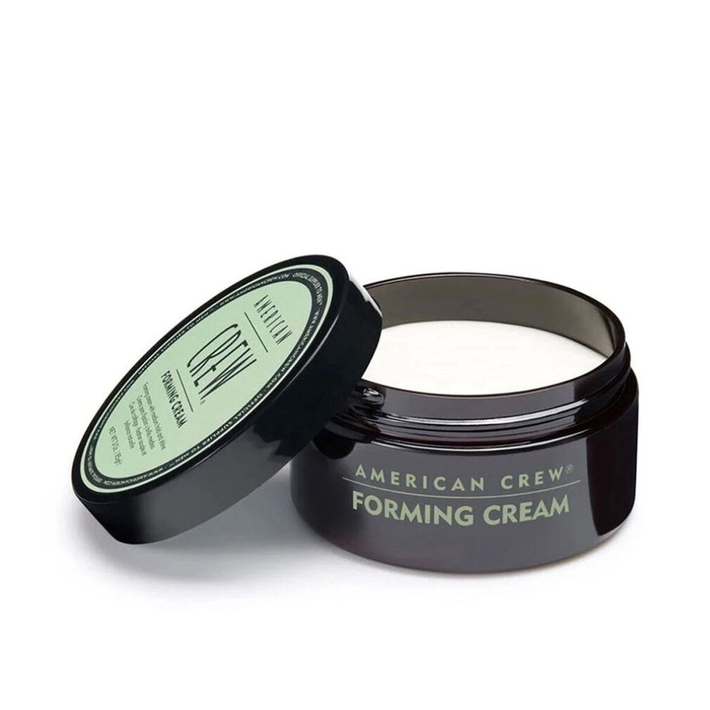 Geöffneter, dunkelbrauner Tiegel mit Deckel daneben. Aufschrift: American Crew Forming Cream. Cremefarbener Inhalt sichtbar.