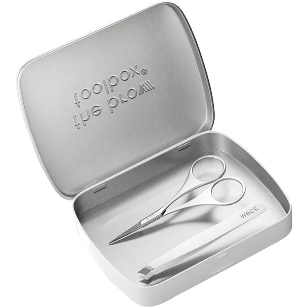 Geöffnete, silberfarbene Dose mit Pinzette und Schere. Aufschrift 'the brow toolbox'. 'WBCo.'-Logo auf der Pinzette.