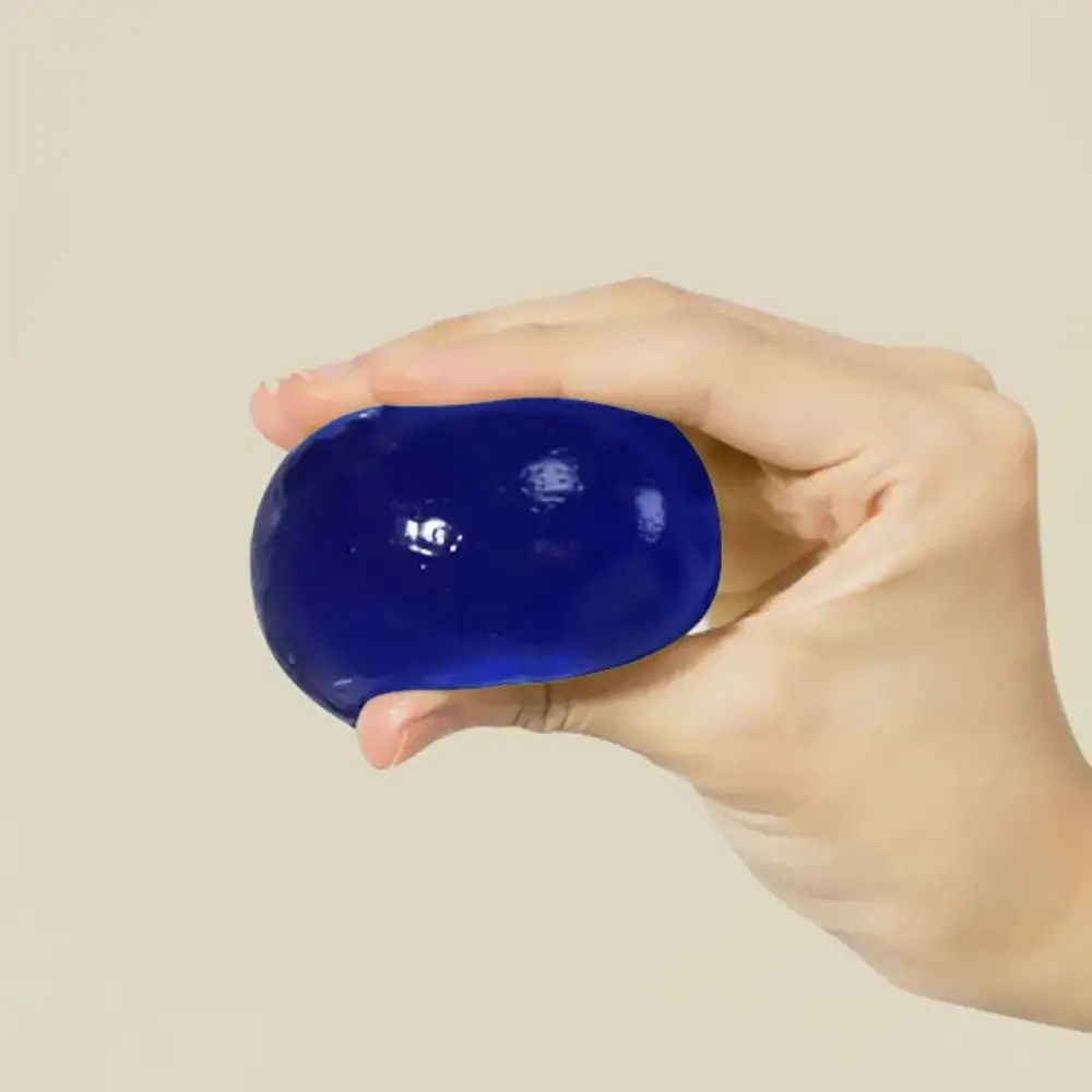 Blauer, ovaler Ball in einer Hand gehalten. Glatte Oberfläche.