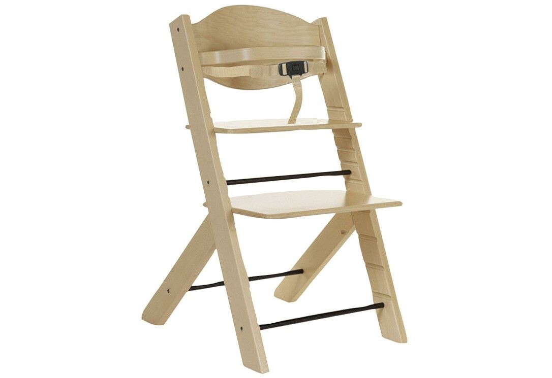 Hochstuhl aus hellem Holz mit Sicherheitsgurt und Fußstütze. Schwarze Querstreben. Schrägansicht.