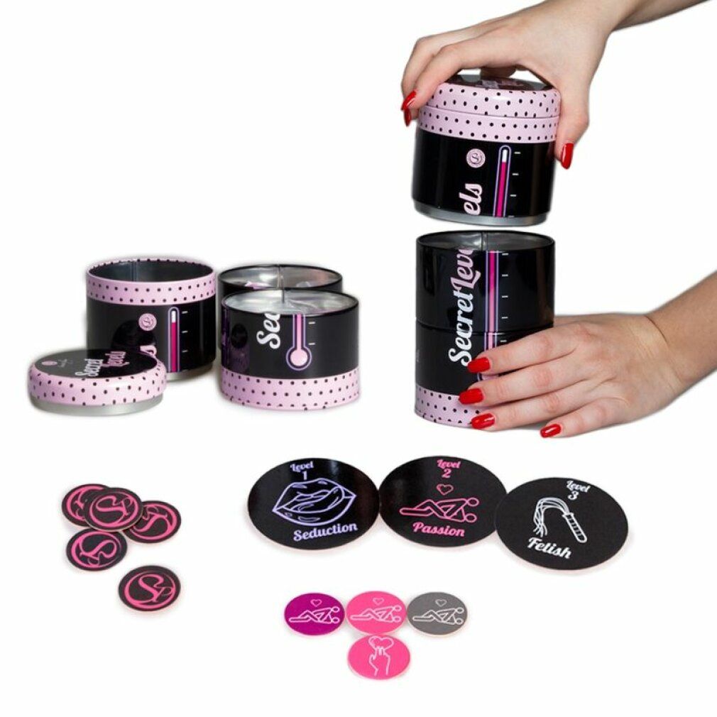 Mehrere Dosen mit "Secret Levels"-Schriftzug. Rosa Thermometer-Design. Spielkarten mit Symbolen und Texten. Rosa, graue Spielchips.