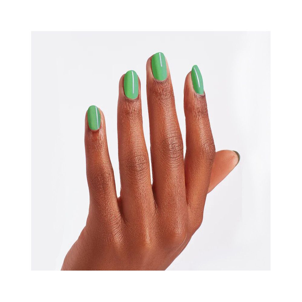 Hand mit lackierten Nägeln. Grüner Nagellack auf fünf Fingern. Helle Haut, weißer Hintergrund.