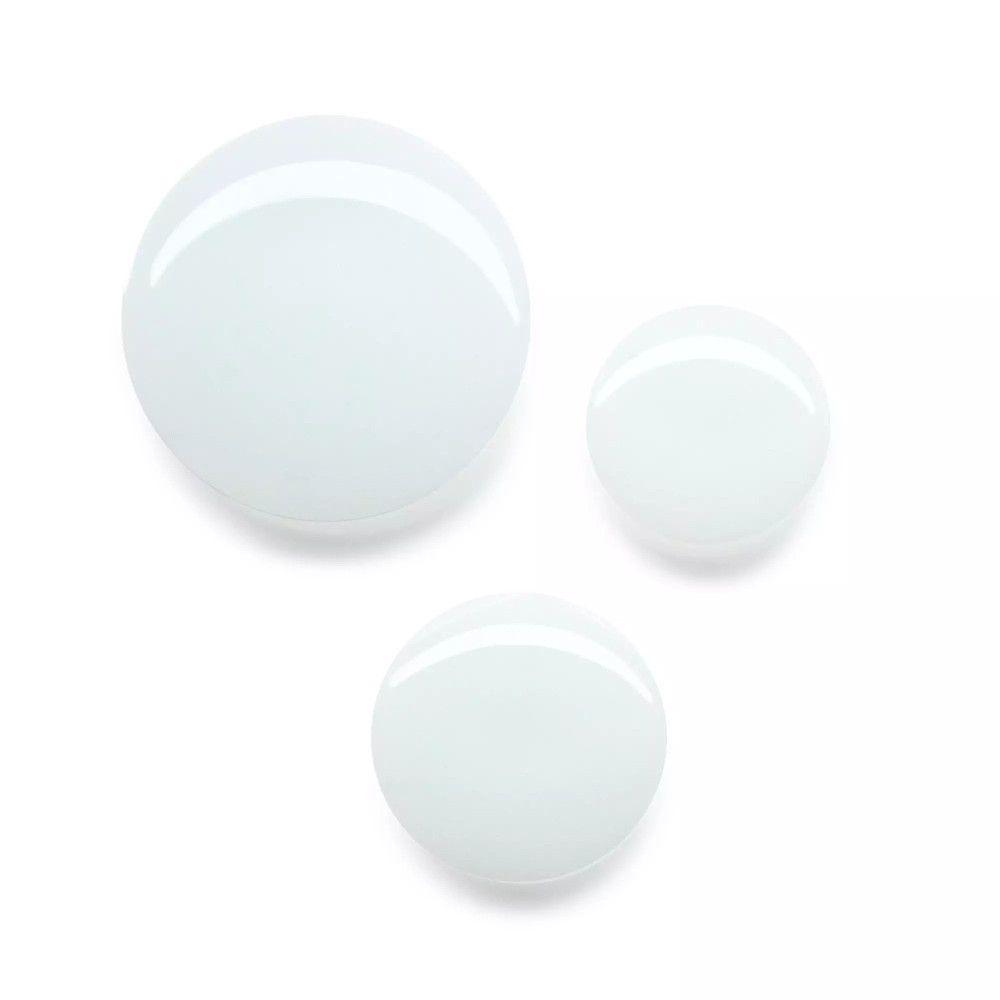 Drei weiße, runde Tropfen auf weißem Hintergrund. Glänzende Oberfläche.