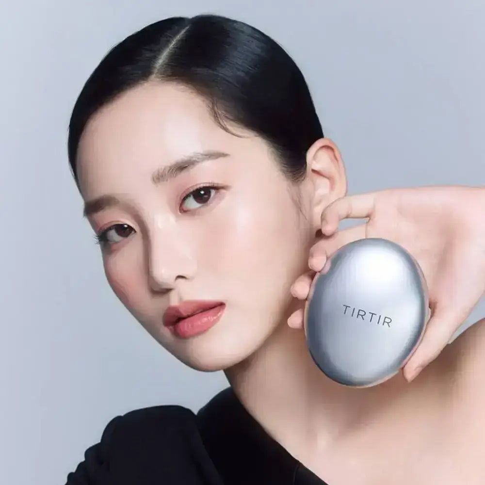 Frau hält TIRTIR Mask Fit Aura Cushion in silberner Dose.