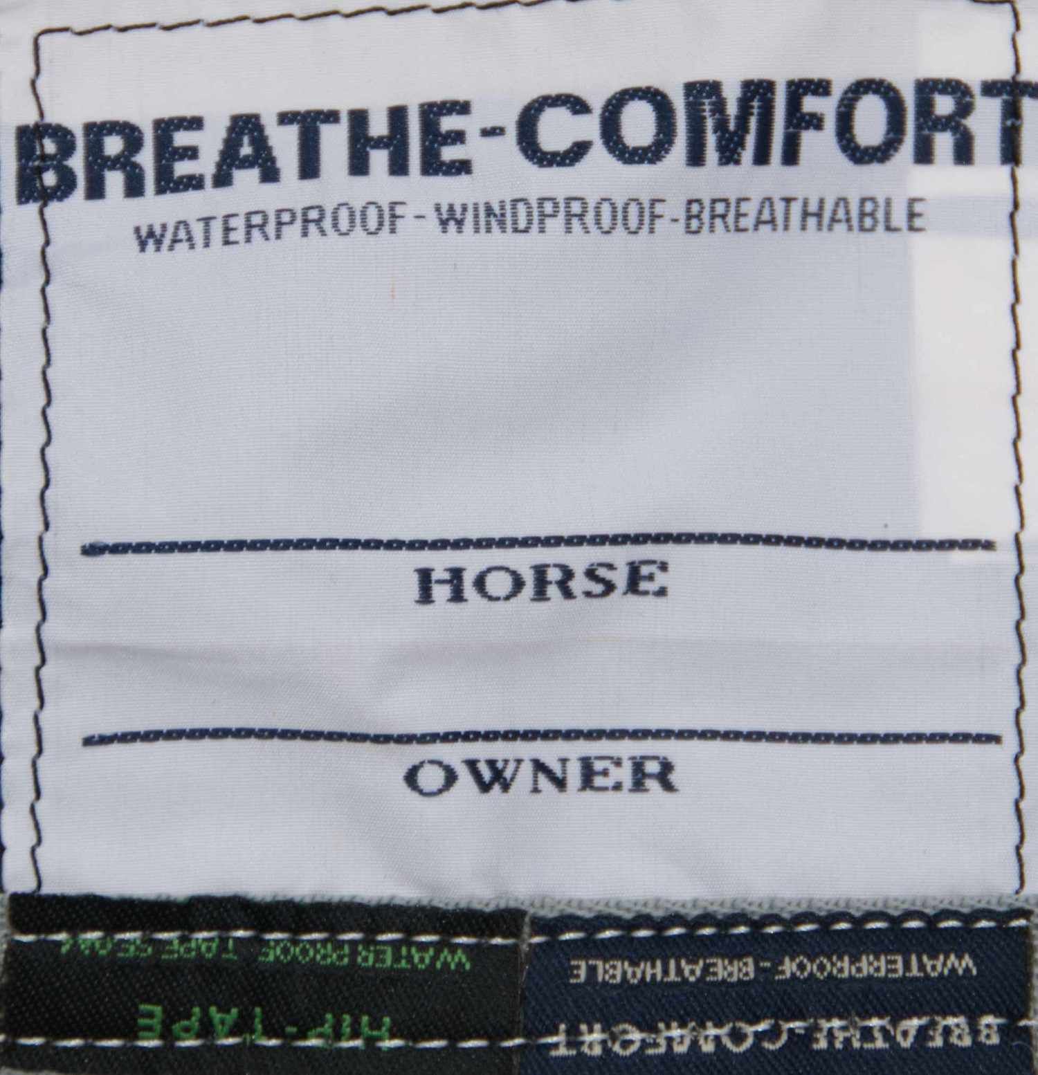 Etikett mit Text: BREATHE-COMFORT, WATERPROOF-WINDPROOF-BREATHABLE, HORSE, OWNER.