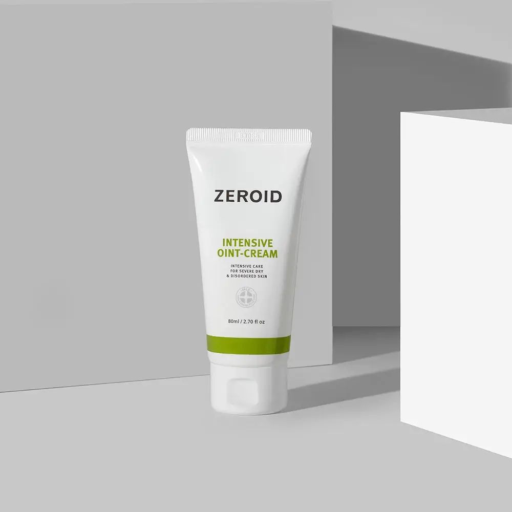 Weiße Tube mit grünem Streifen. Aufschrift ZEROID, INTENSIVE OINT-CREAM. Produkt vor grauem Hintergrund.