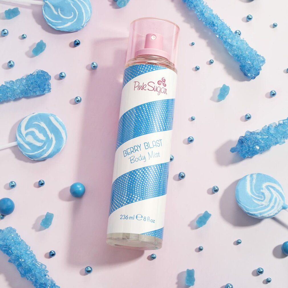 Körpernebel mit blau-weißem Streifenmuster. Rosa Sprühkopf. Text: Pink Sugar, Berry Blast Body Mist, 236 ml 8 fl oz. Umgeben von Süßigkeiten.