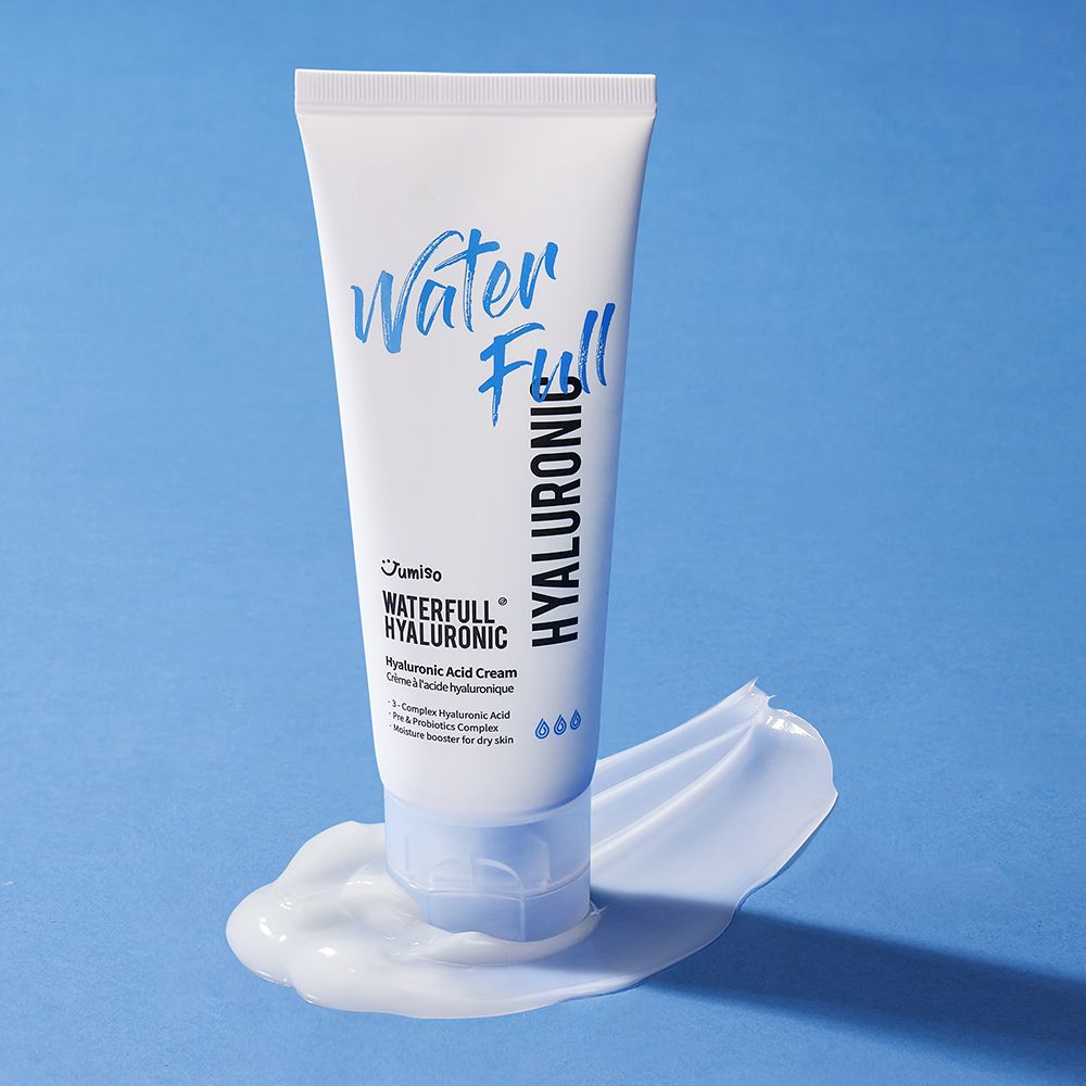 Weiße Tube mit blauem Schriftzug "Water Full Hyaluronic" auf blauem Untergrund. Creme daneben.