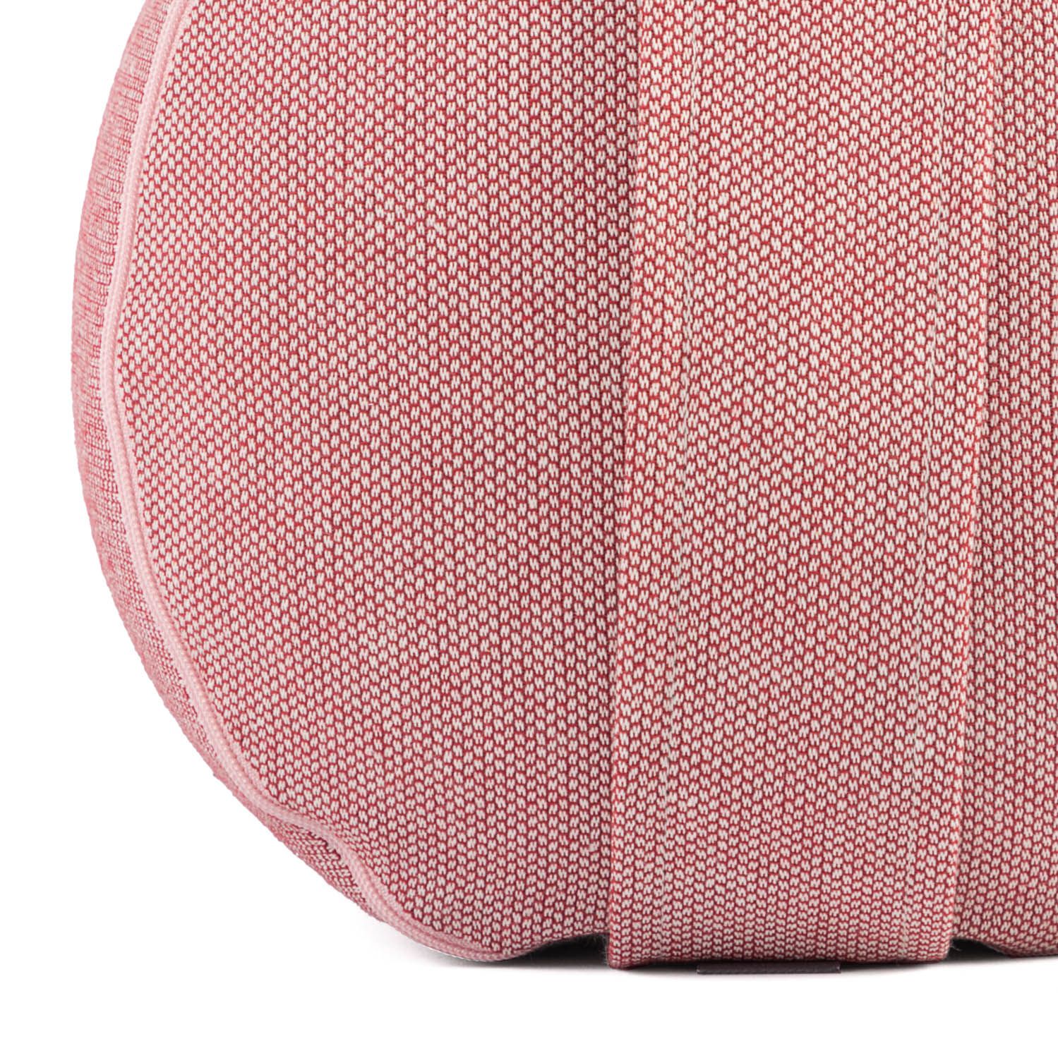 Nahaufnahme eines rosa Yoga-Bolsters. Runde Form, Stoffstruktur mit vertikalen Nähten.