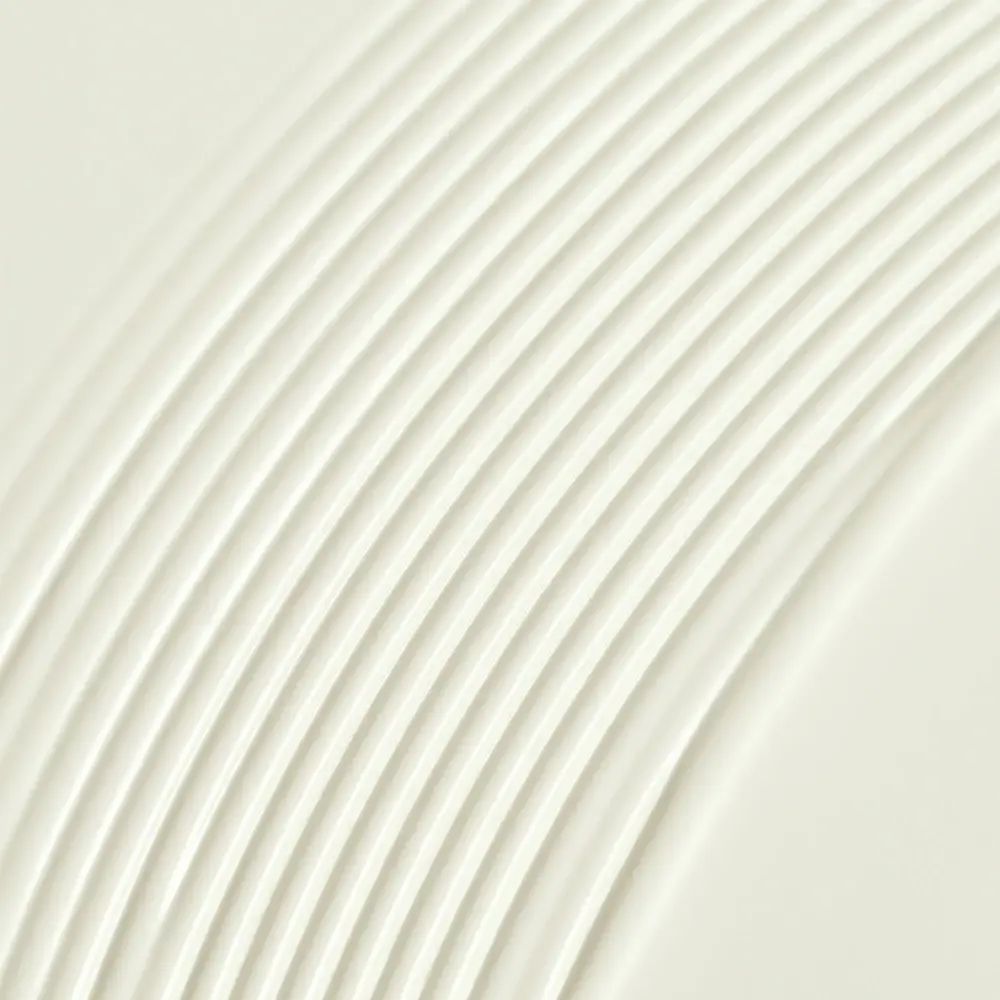 Nahaufnahme einer cremigen, weißen Substanz mit geriffelter Oberfläche.