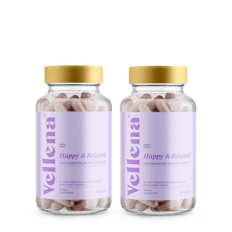 Zwei Flaschen mit Kapseln. Aufschrift: Vellena Happy & Relaxed. Kapseln in Glasflaschen mit goldenen Deckeln. Weißer Hintergrund.