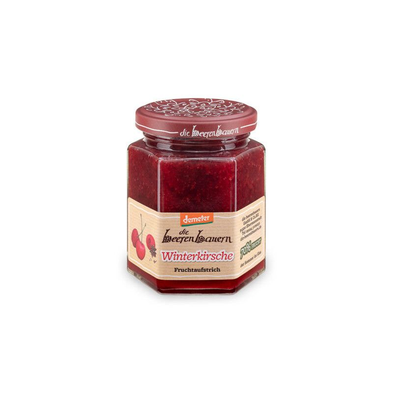 Sechseckiges Glas mit rotem Inhalt und rotem Deckel. Auf dem Etikett steht "die beerenbauern Winterkirsche Fruchtaufstrich".