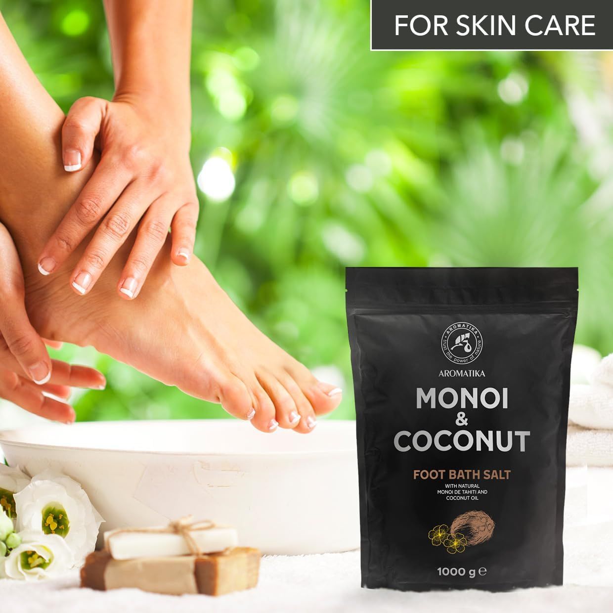 Produktverpackung neben einem Fuß in einer Schüssel. Text: Monoi & Coconut Foot Bath Salt. Daneben Seife und Blüten.
