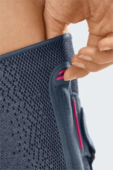 Detail der Knieorthese: Pinke Schlaufe zum einfachen Anlegen der Orthese, integriert in den oberen Bund.