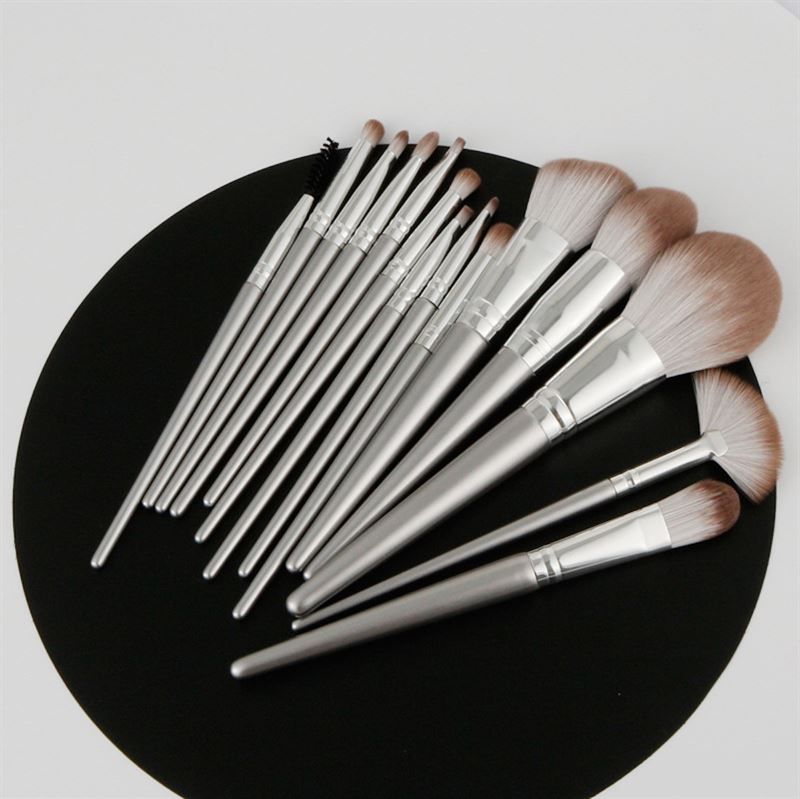 Make-up-Pinsel-Set auf schwarzem Untergrund. Verschiedene Pinselformen mit silberfarbenen Griffen.