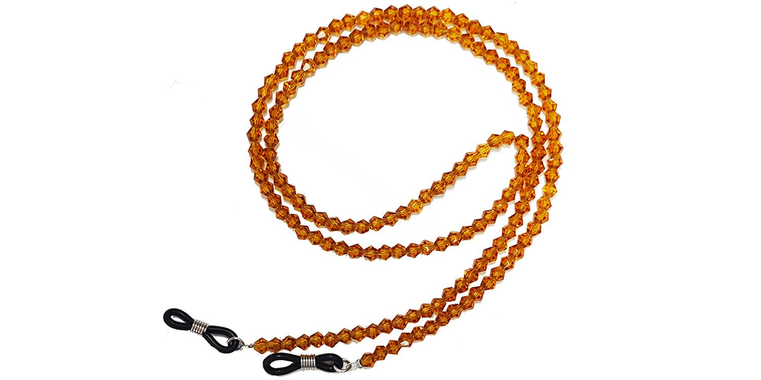 Brillenkette mit bernsteinfarbenen Perlen. Schwarze Silikon-Schlaufen zur Befestigung an Brillenbügeln.