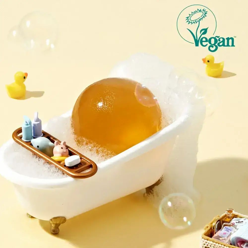 Gelbe Kugel in einer Badewanne mit Schaum. Vegan-Logo. Enten-Dekoration.