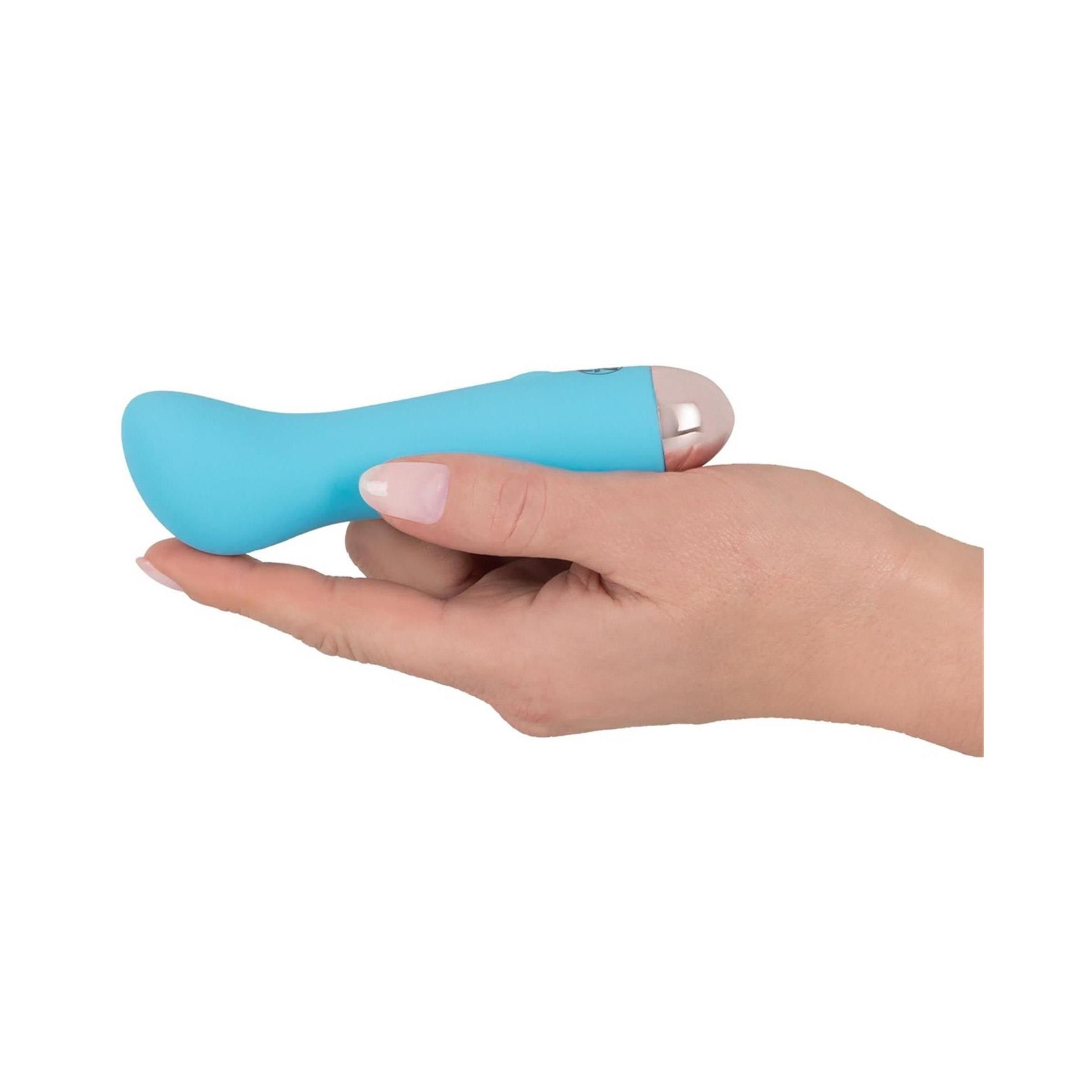 Blauer Vibrator in einer Hand gehalten. Rosa Spitze.
