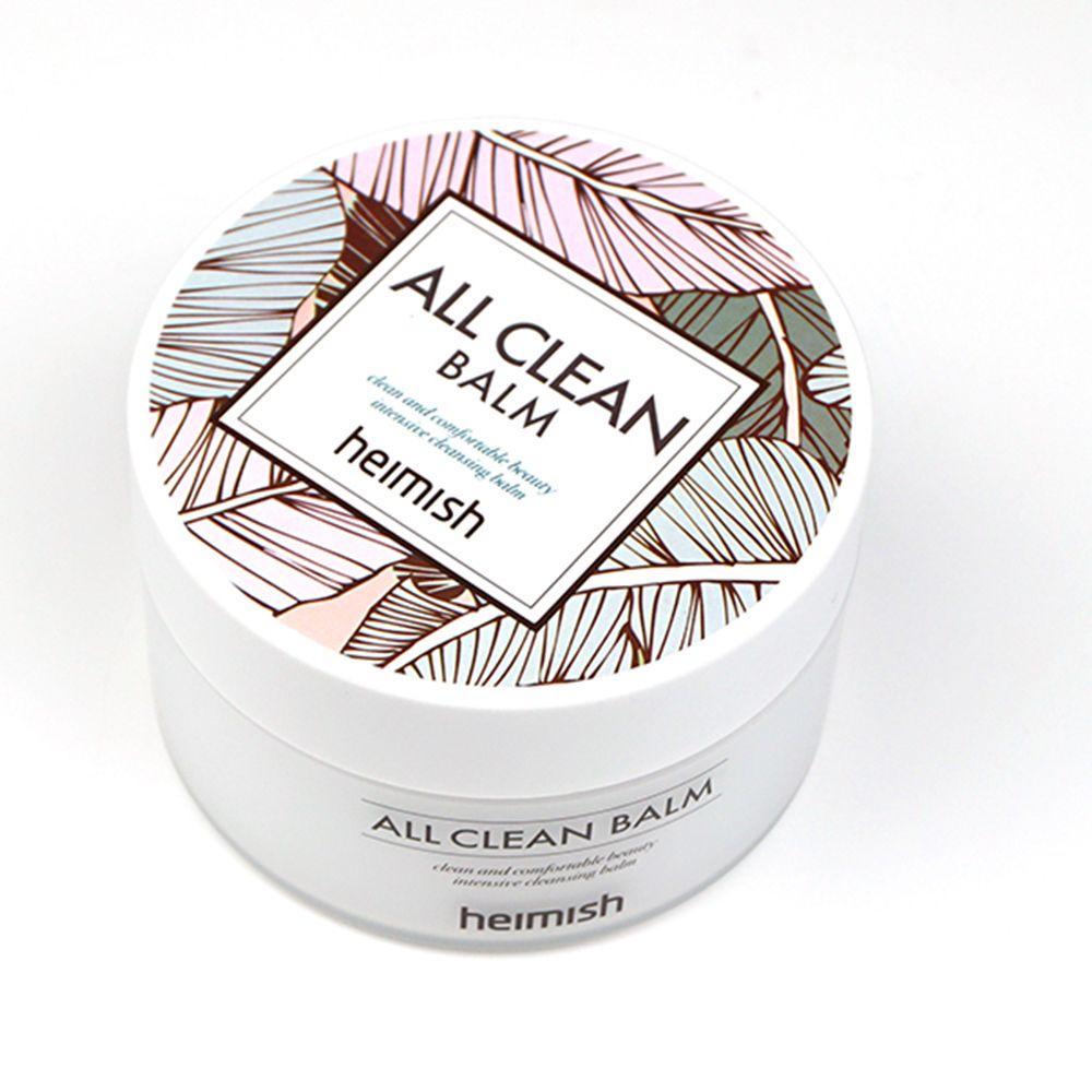 Heimish All Clean Balm in einem weißen Tiegel mit einem Deckel mit Blattmuster. Der Tiegel steht auf einem Handtuch.