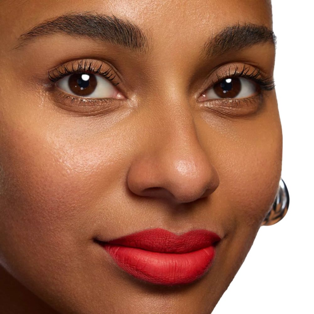 Nahaufnahme eines Gesichts mit rotem Lippenstift. Dunkle Haut, braune Augen, silberne Ohrringe.