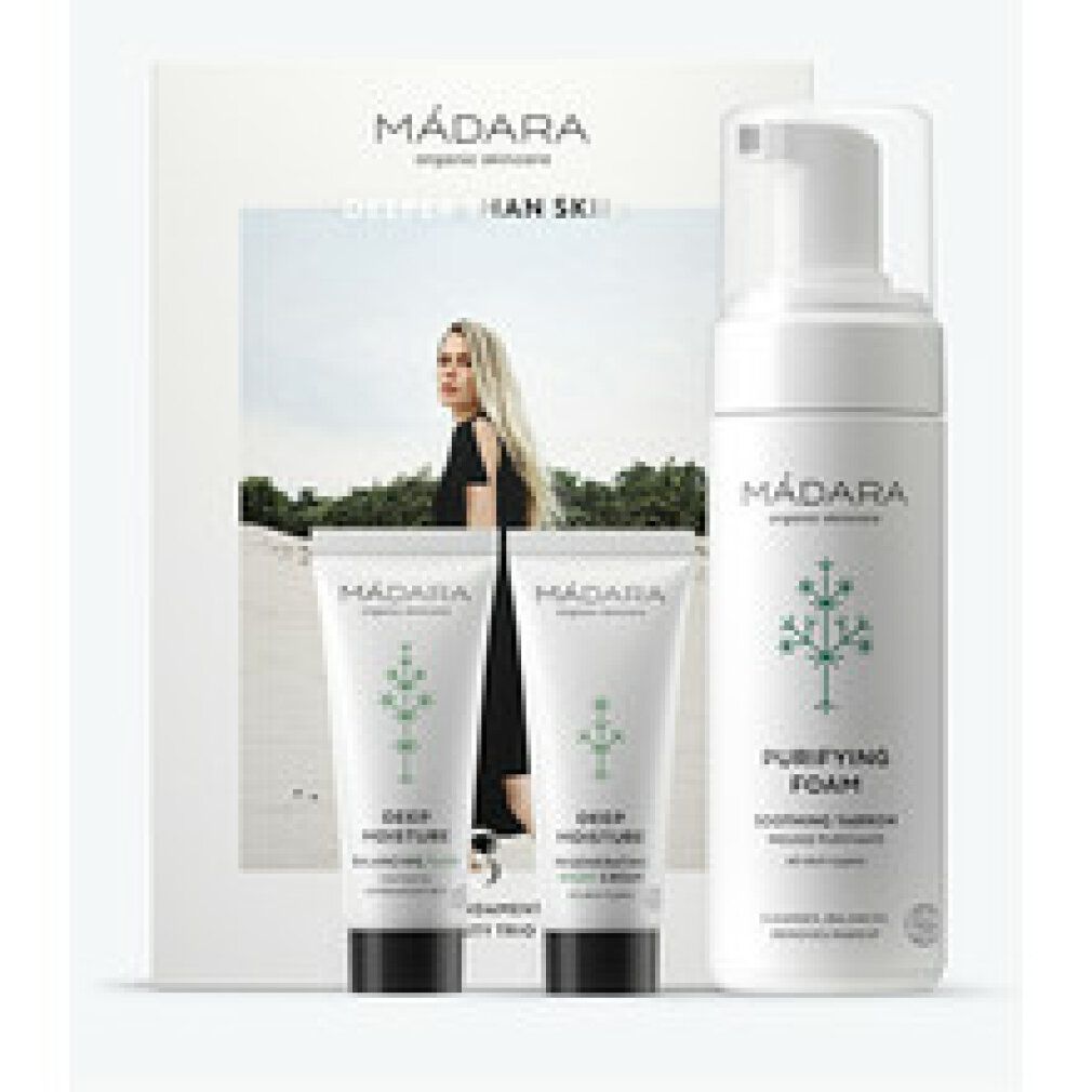 Geschenkset mit drei Hautpflegeprodukten und einer Karte. Die Produkte sind in weißen Behältern mit grünen Akzenten verpackt. Auf der Karte ist eine Frau abgebildet.