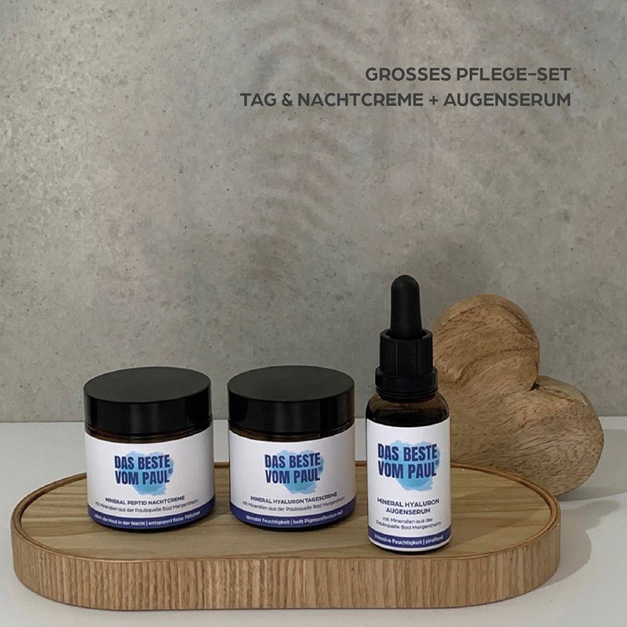 Drei Produkte auf einem Holztablett. Produkte: Tagescreme, Nachtcreme, Augenserum. Aufschrift: Das Beste vom Paul.