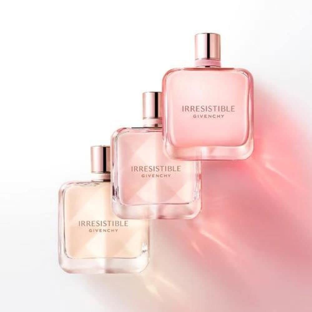 Drei Givenchy Irresistible Flakons. Rosa Flakons mit rosafarbenen Deckeln. Schriftzug Irresistible Givenchy.
