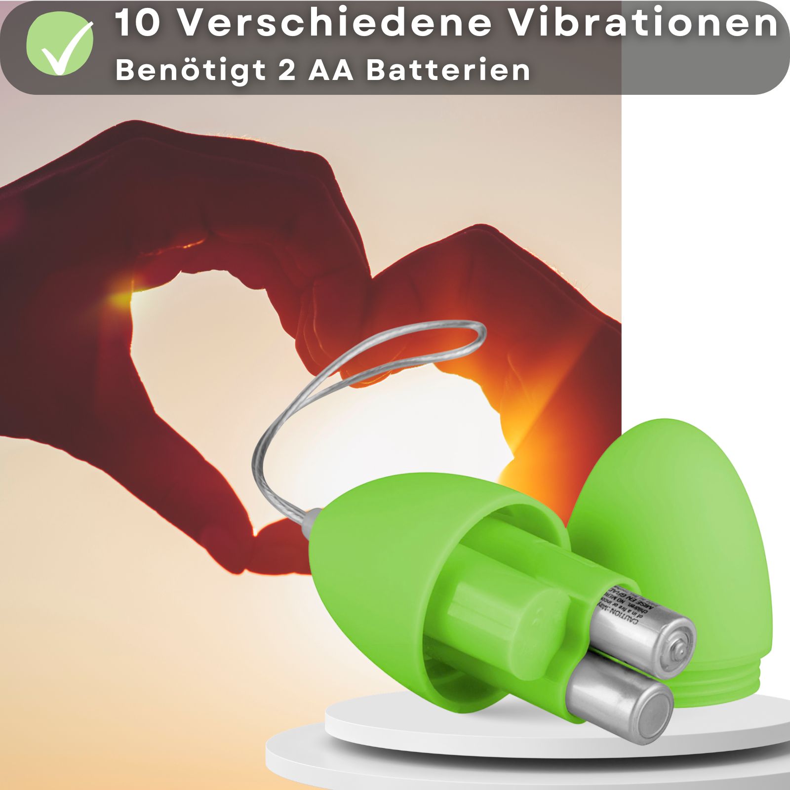Grünes, ovales Produkt mit Deckel. Im Inneren zwei Batterien. Text: 10 Vibrationen. Auf weißem Podest.