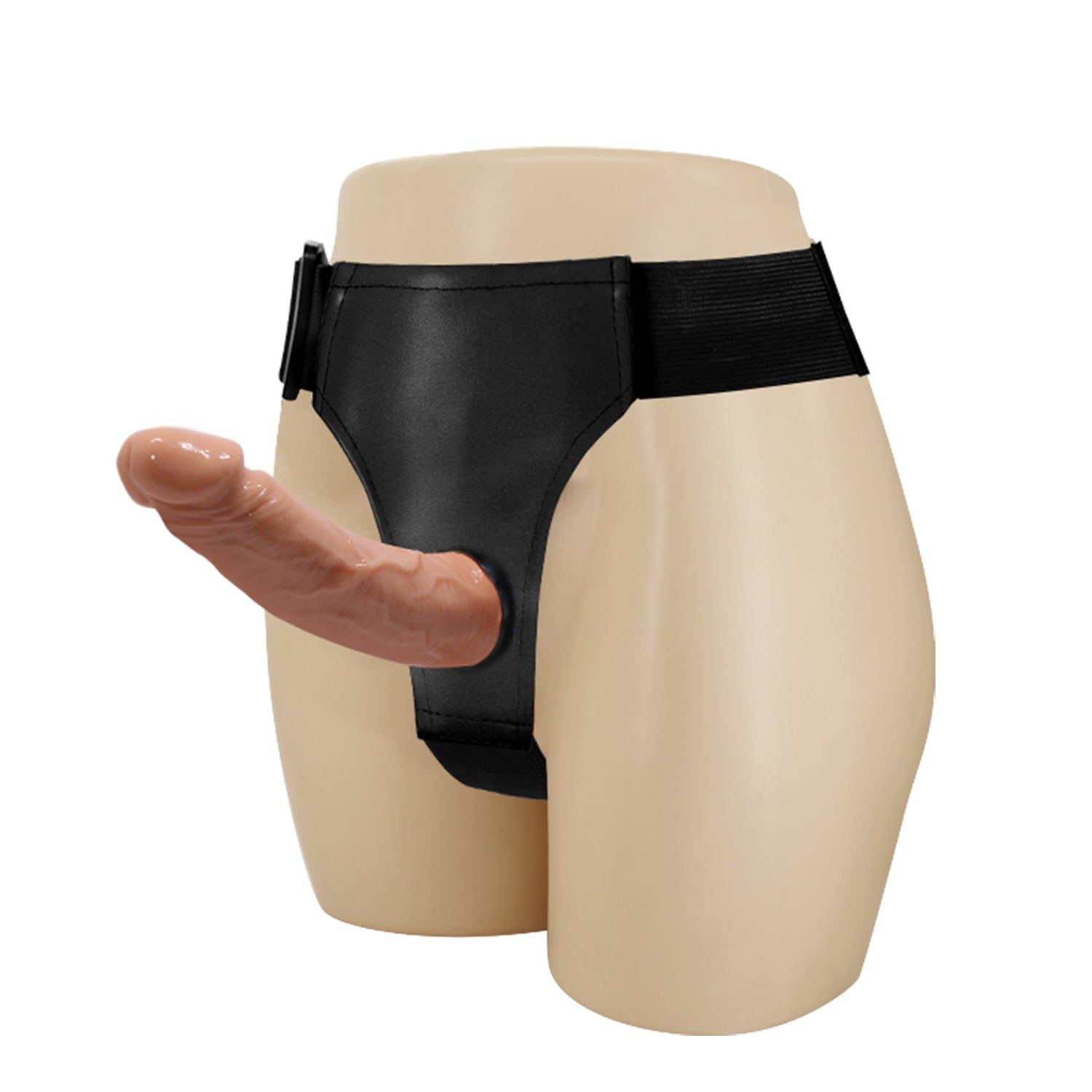 Schwarzes Geschirr mit einem beigefarbenen Dildo. Das Geschirr ist an einem Modell befestigt.