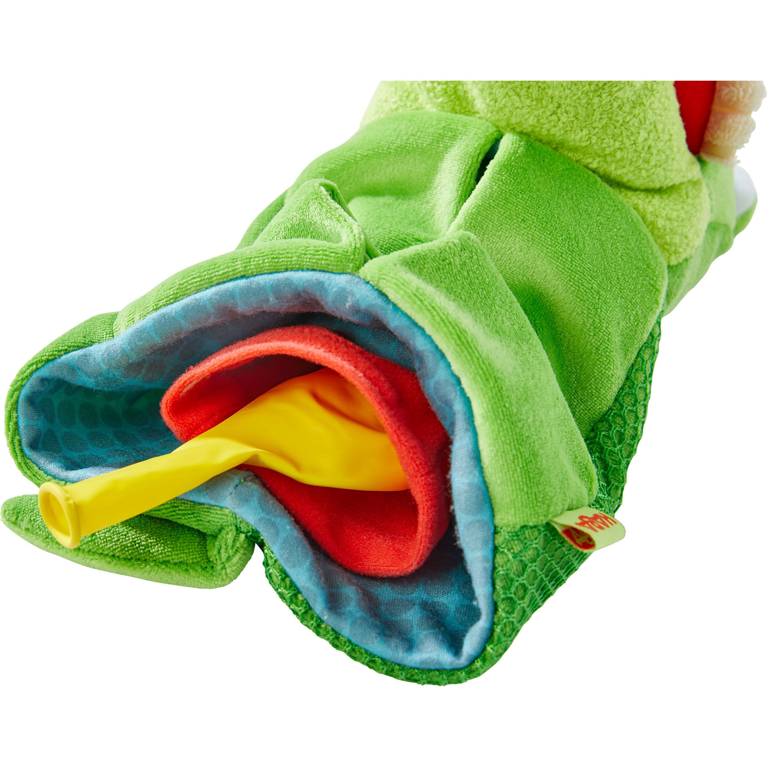 Nahaufnahme der geöffneten Maul der grünen Krokodil-Handpuppe. Rotes und gelbes Spielzeug sichtbar. HABA-Logo.
