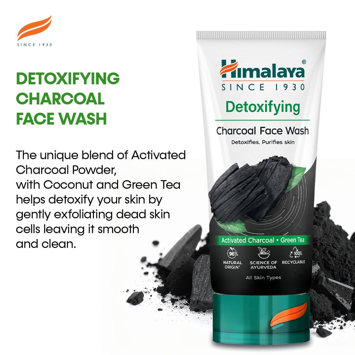 Himalaya Entgiftende Gesichtsreinigung mit Aktivkohle & Grünem Tee Tube, umgeben von Aktivkohlebrocken und Blättern.