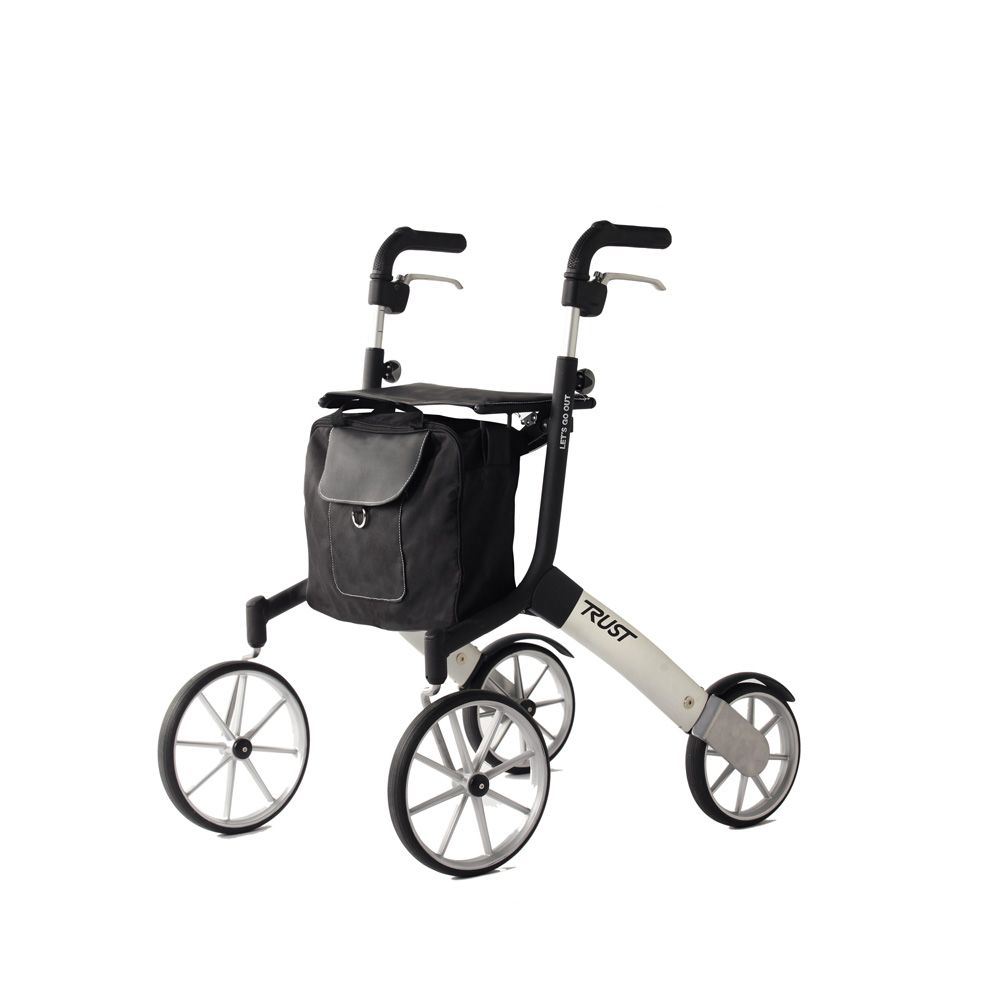 Rollator schwarz-silber mit vier Rädern und Einkaufstasche. Griffe, Rahmen und Räder sichtbar. Marke Trust.