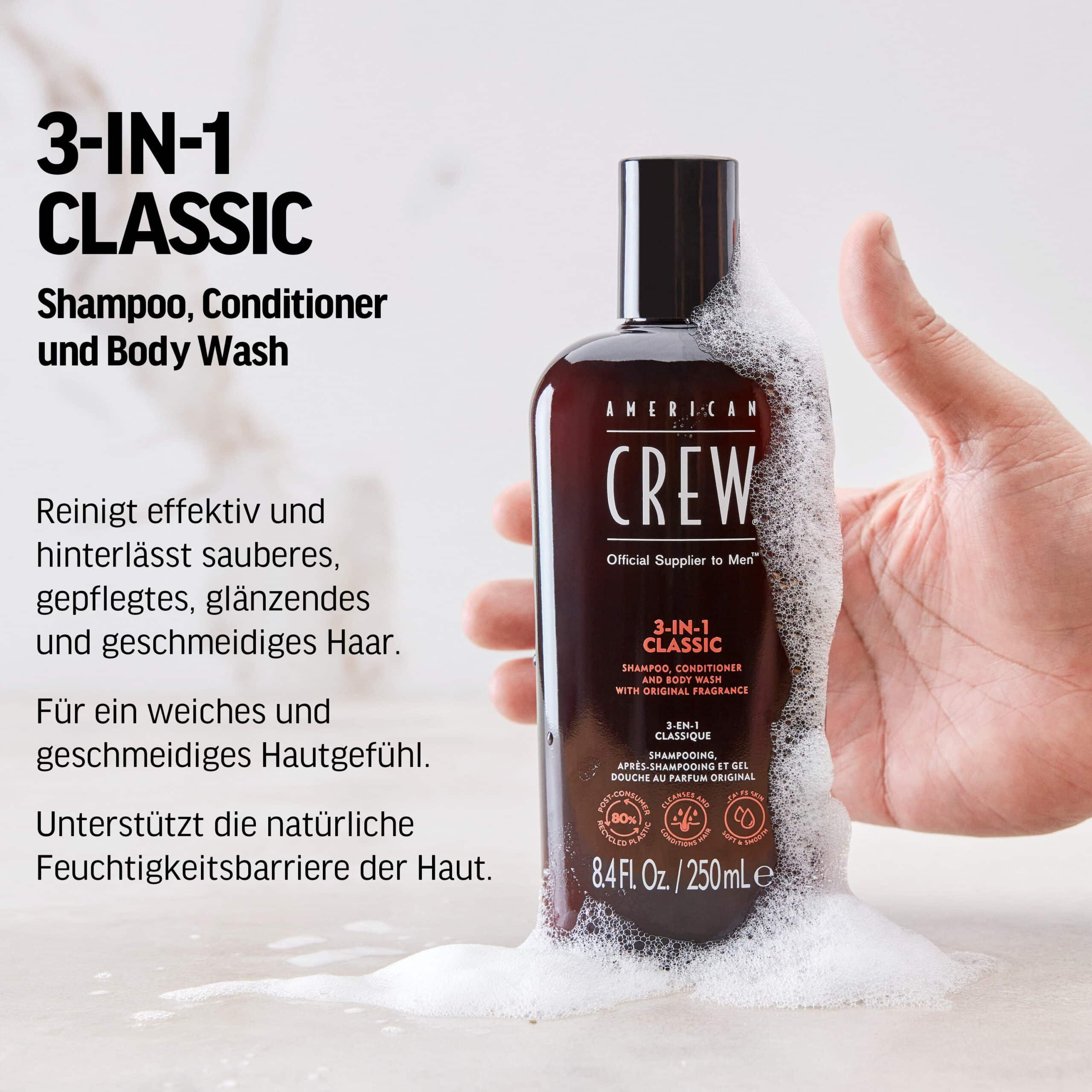AMERICAN CREW 3-in-1 Classic Shampoo-Flasche, umgeben von Schaum. Schwarzer Deckel. Text: Shampoo, Conditioner und Body Wash. 250 ml.