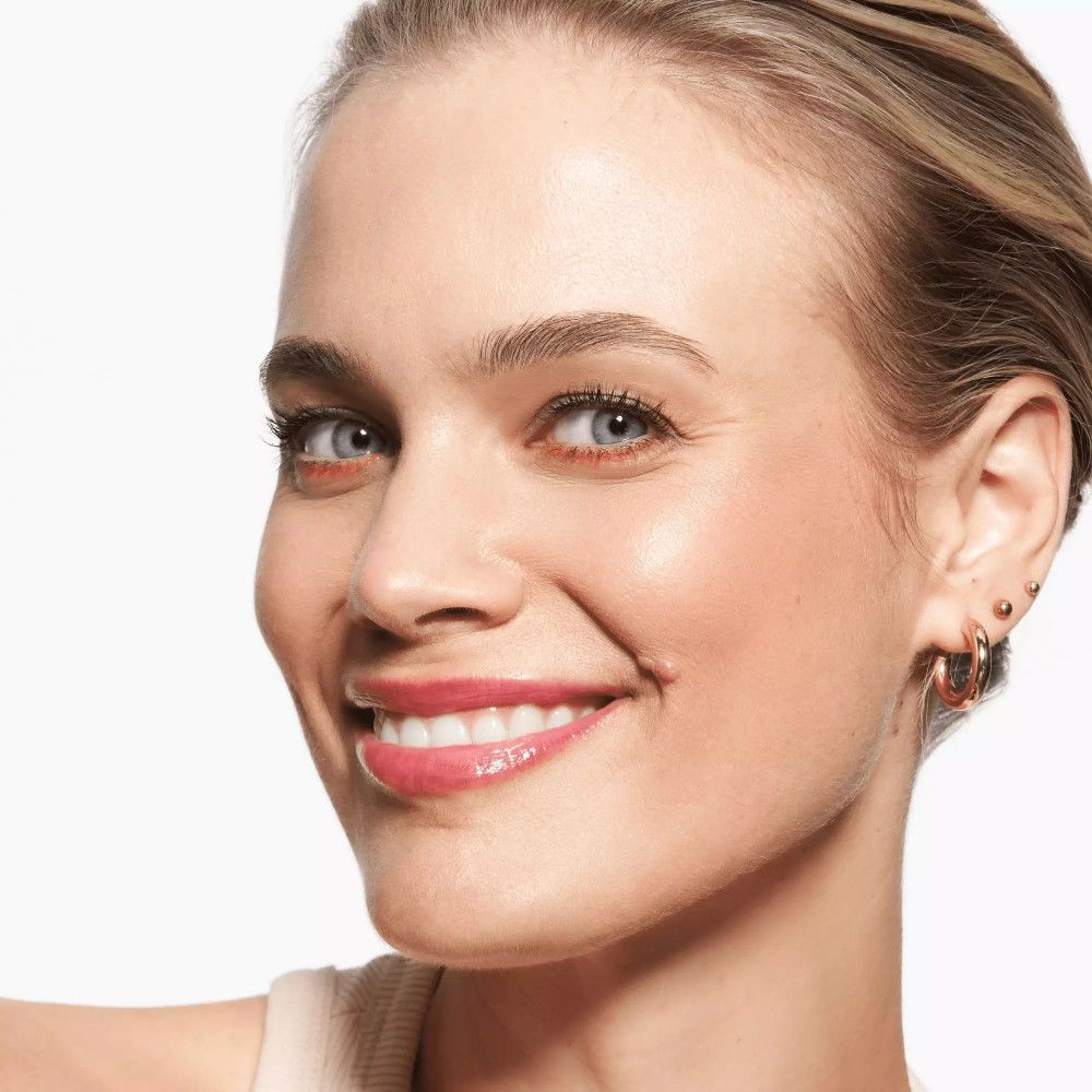 Frau mit Kajalstift-Strich am oberen Augenlid. Goldene Ohrringe.