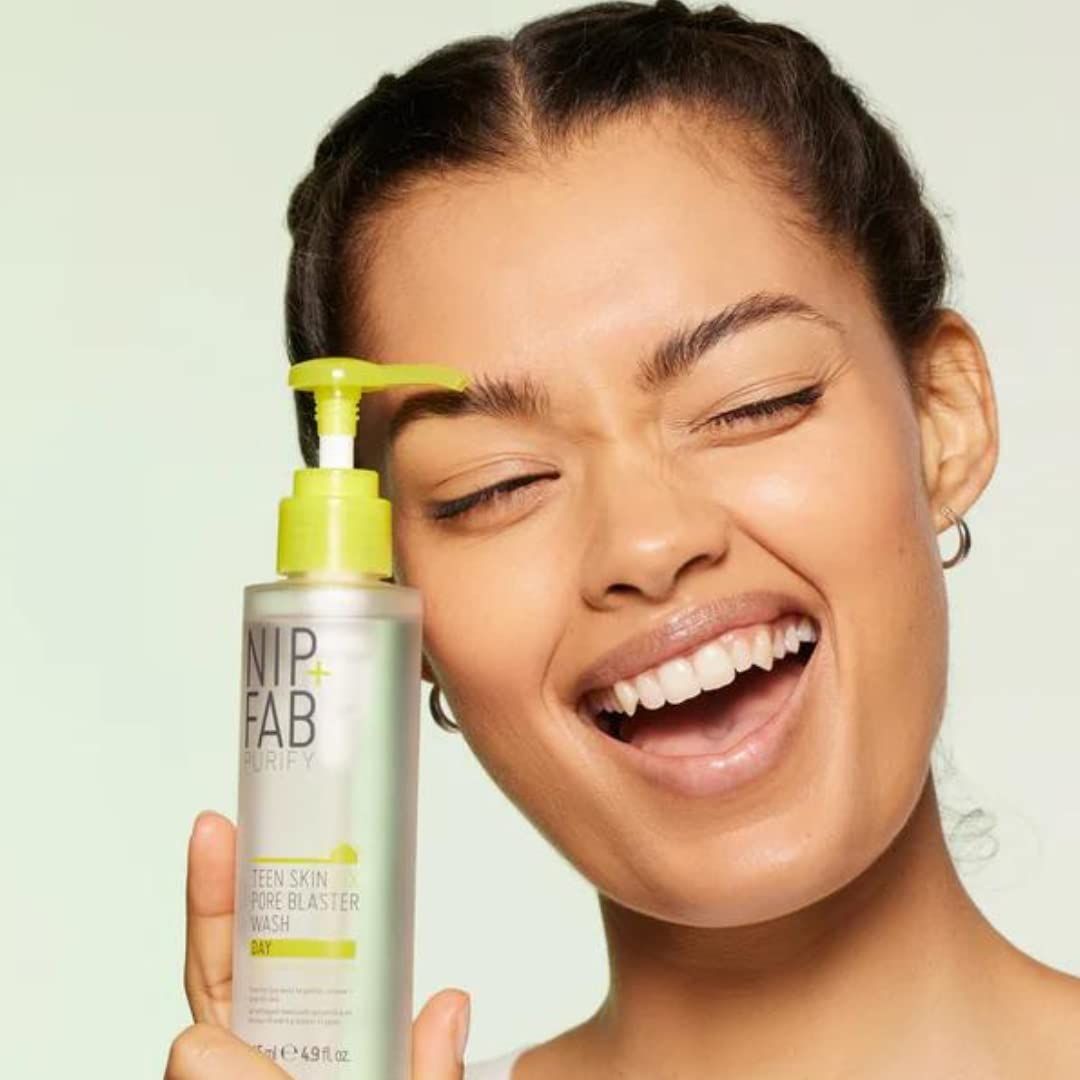 Frau hält Produktflasche mit gelbem Pumpkopf. Aufschrift: NIP+FAB PURIFY, Teen Skin Fix Pore Blaster Wash.