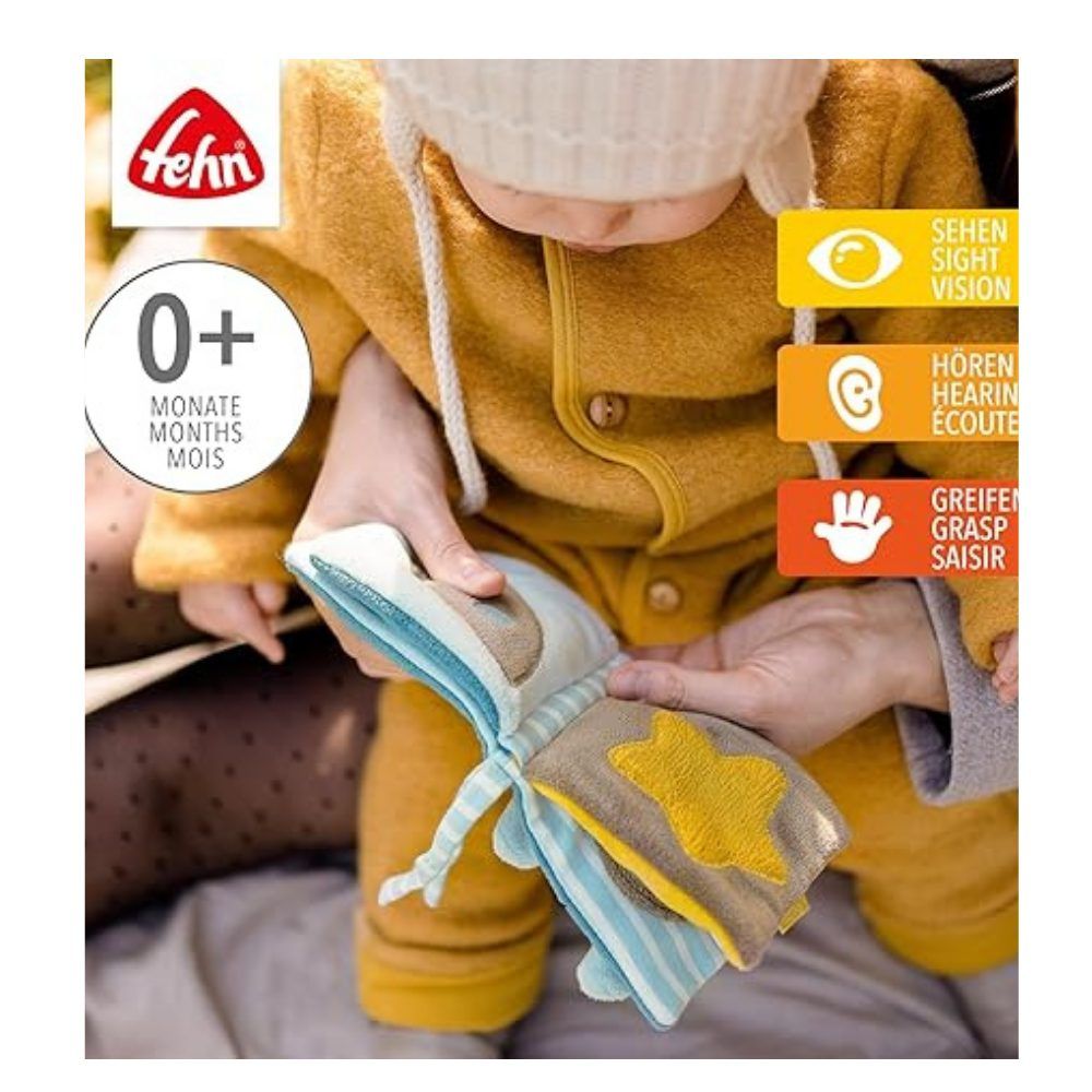 Baby hält Stoffbuch mit Stern-Motiv. Marke: fehn. Altersempfehlung: 0+. Visuelle und taktile Elemente. 