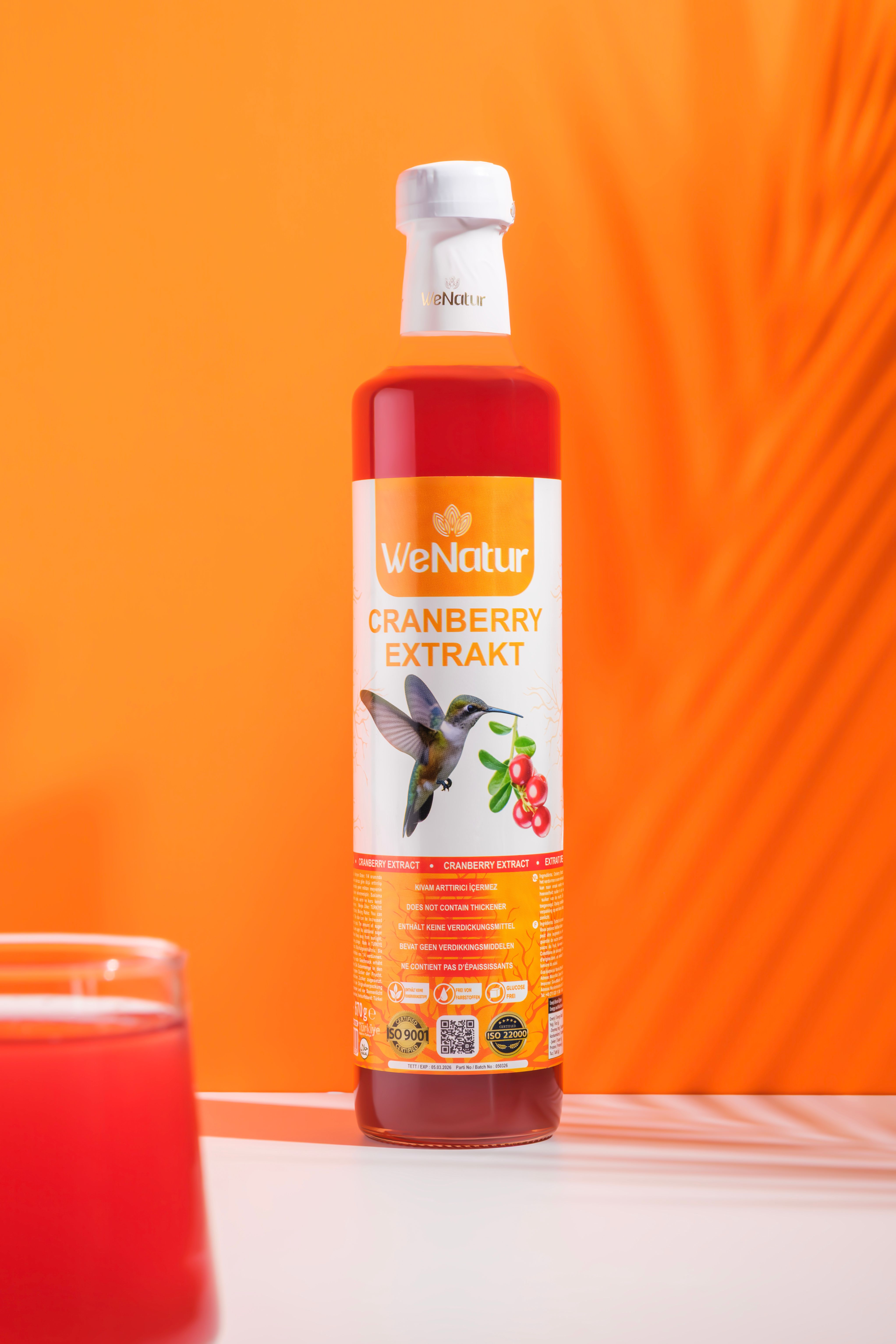 Flasche mit Cranberry-Extrakt, Etikett mit Kolibri und Beeren.