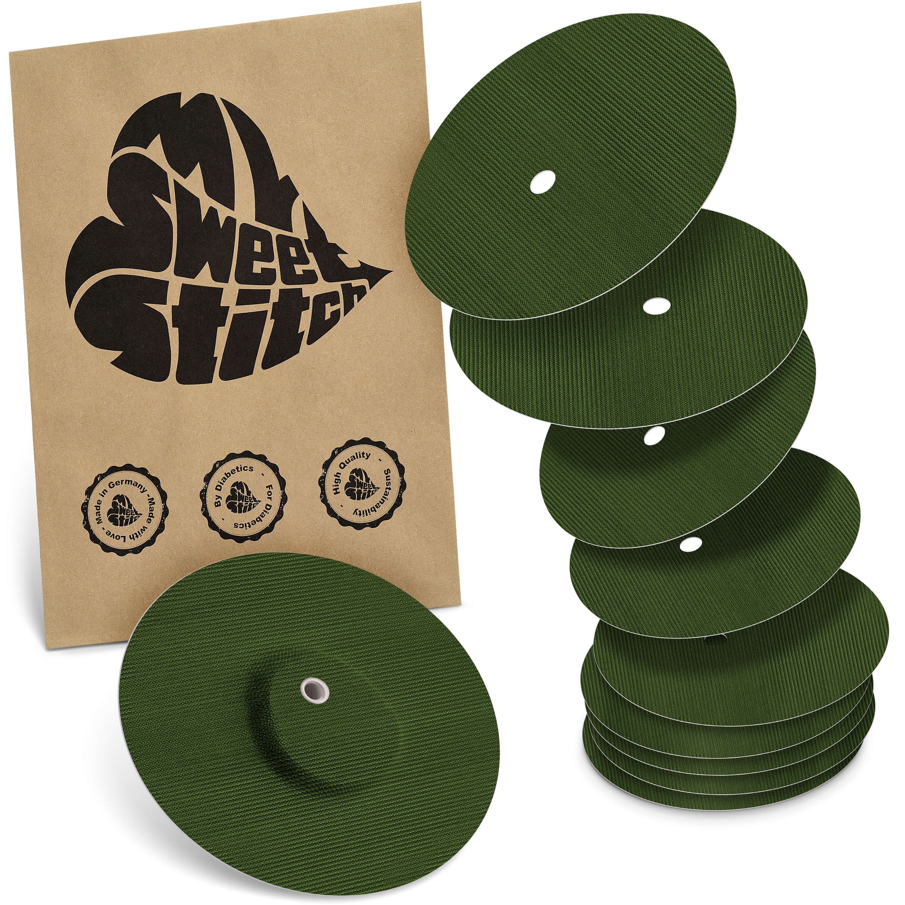 Mehrere runde, grüne Pflaster mit Loch, neben einer braunen Verpackung mit Logo.