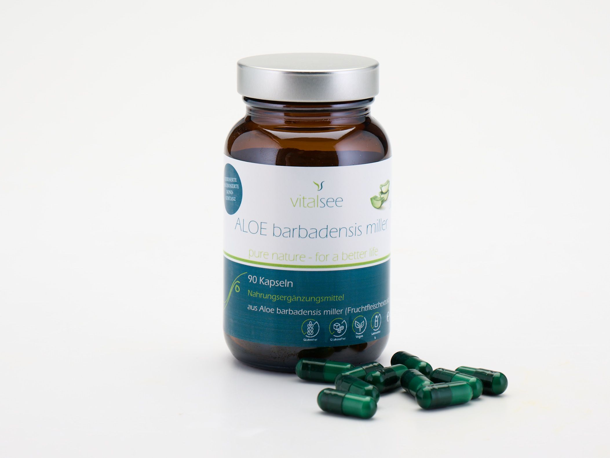 Braune Glasflasche mit silbernem Deckel und grünen Kapseln daneben. Etikett mit Produktnamen und 90 Kapseln.