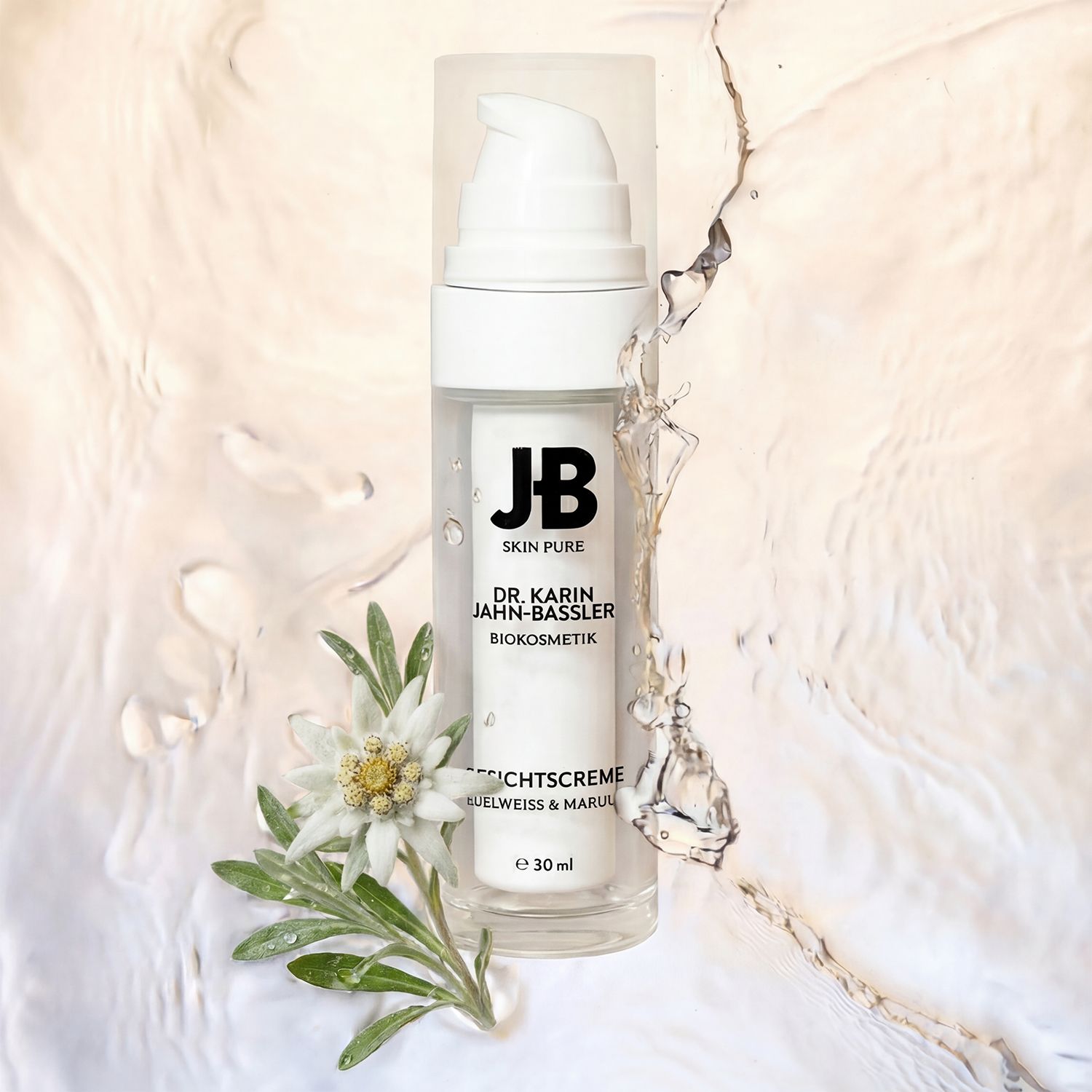 Gesichtscreme-Spender mit transparentem Gehäuse und weißem Pumpkopf. Aufschrift: JB SKIN PURE, DR. KARIN JAHN-BASSLER, GESICHTSCREME, 30 ml. Mit Wasser und Edelweiß.