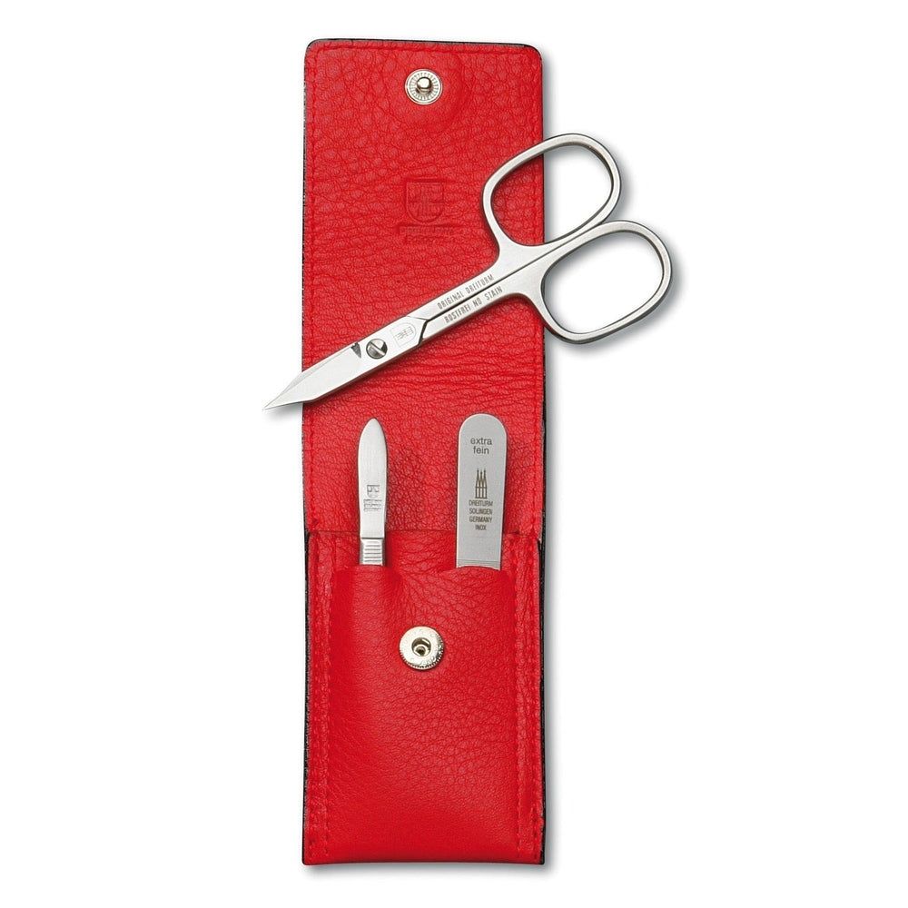 Rotes Maniküre-Etui mit Schere, Nagelfeile und Nagelknipser. Etui aus Leder, mit Druckknopfverschluss. Werkzeuge aus Metall.