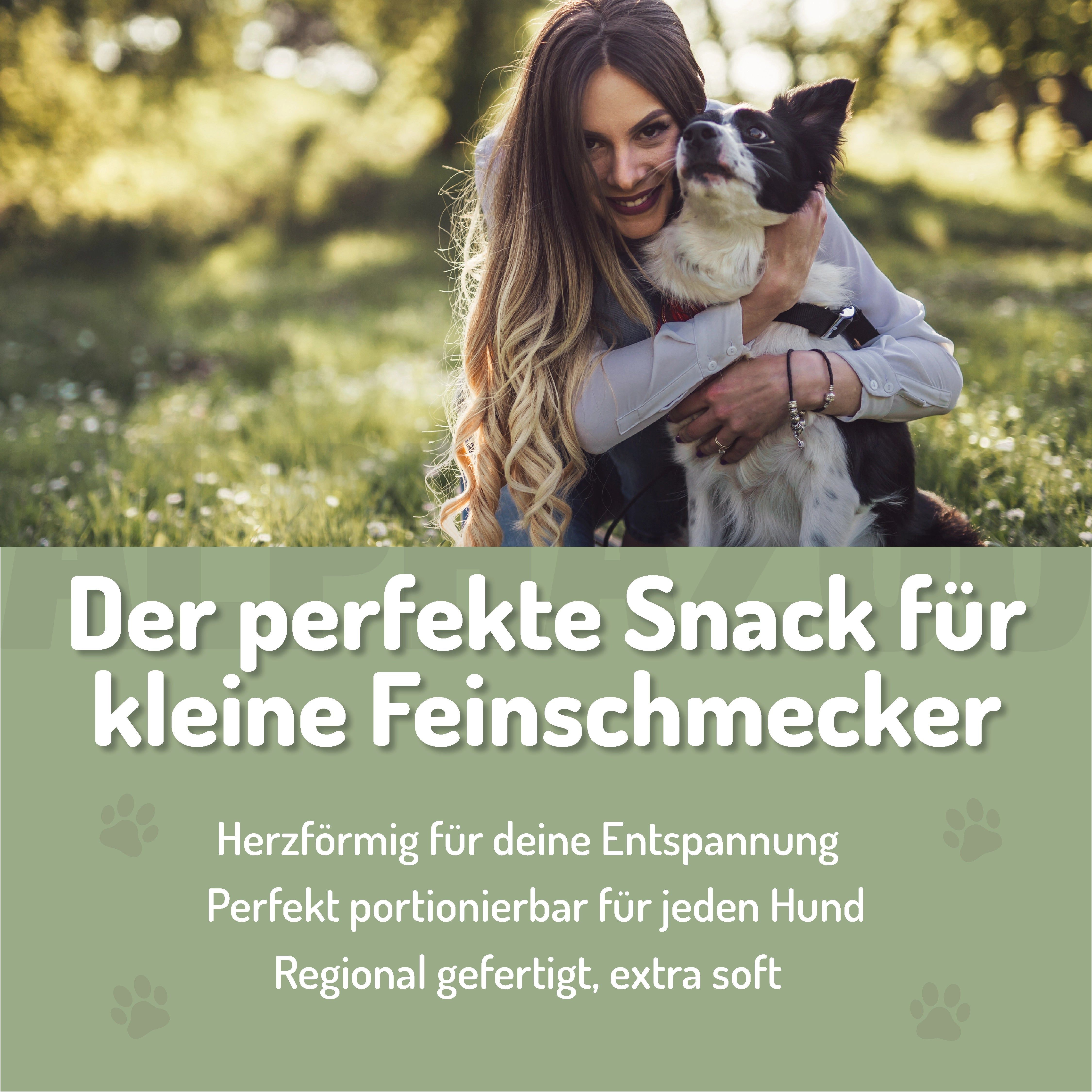 Frau umarmt Hund. Text: "Der perfekte Snack für kleine Feinschmecker". Herzförmige Snacks, extra weich.