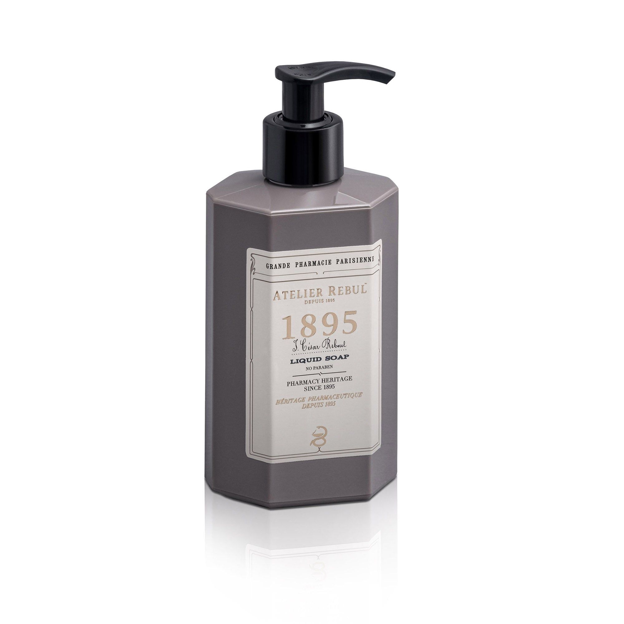 Graue Flasche mit schwarzem Pumpkopf. Aufschrift: Atelier Rebul 1895 Liquid Soap. Auf weißem Hintergrund.