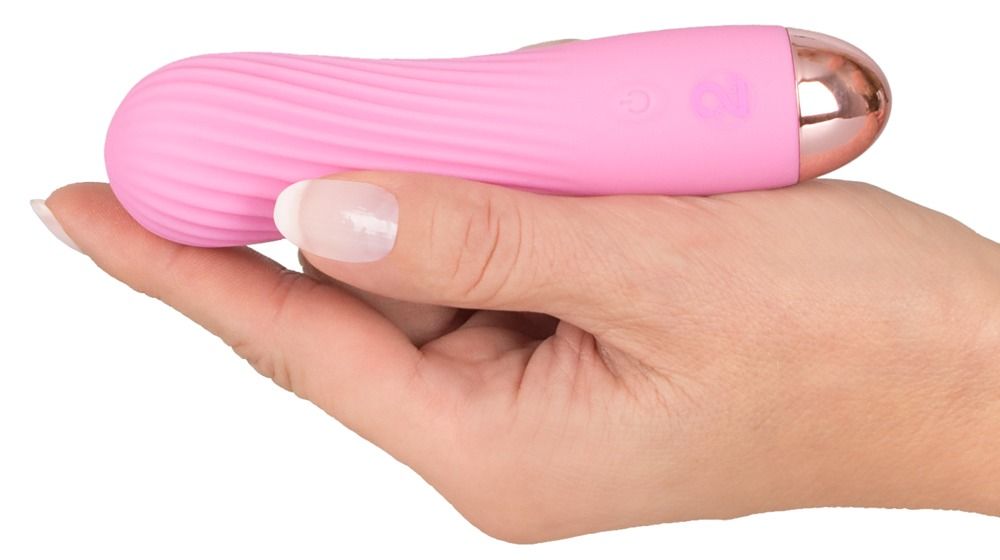 Hand hält einen pinken Mini-Vibrator mit gerillter Oberfläche und goldener Spitze.