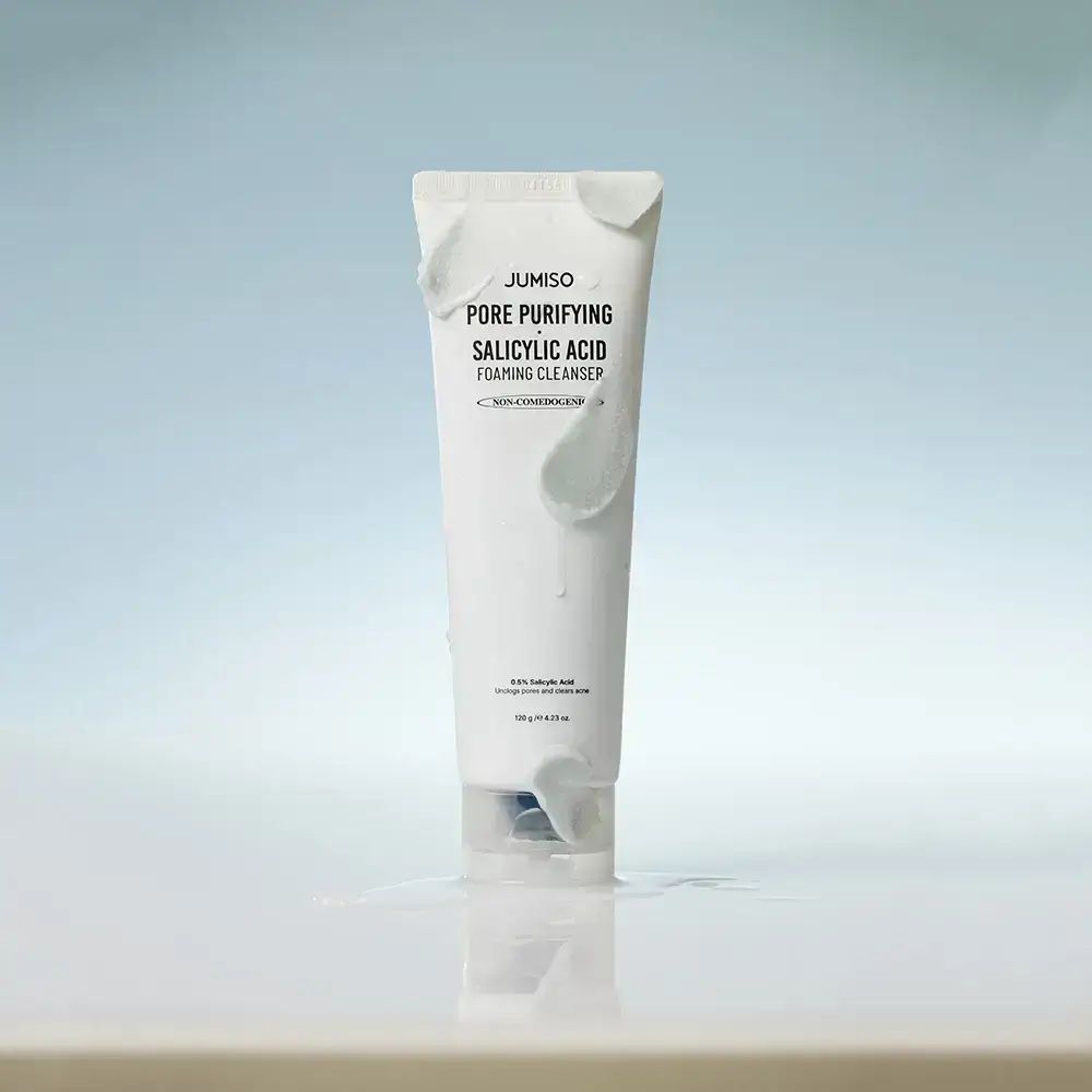 Weiße Tube mit Schaum. Aufschrift: JUMISO Pore Purifying Salicylic Acid Foaming Cleanser. Liegt in Wasser.
