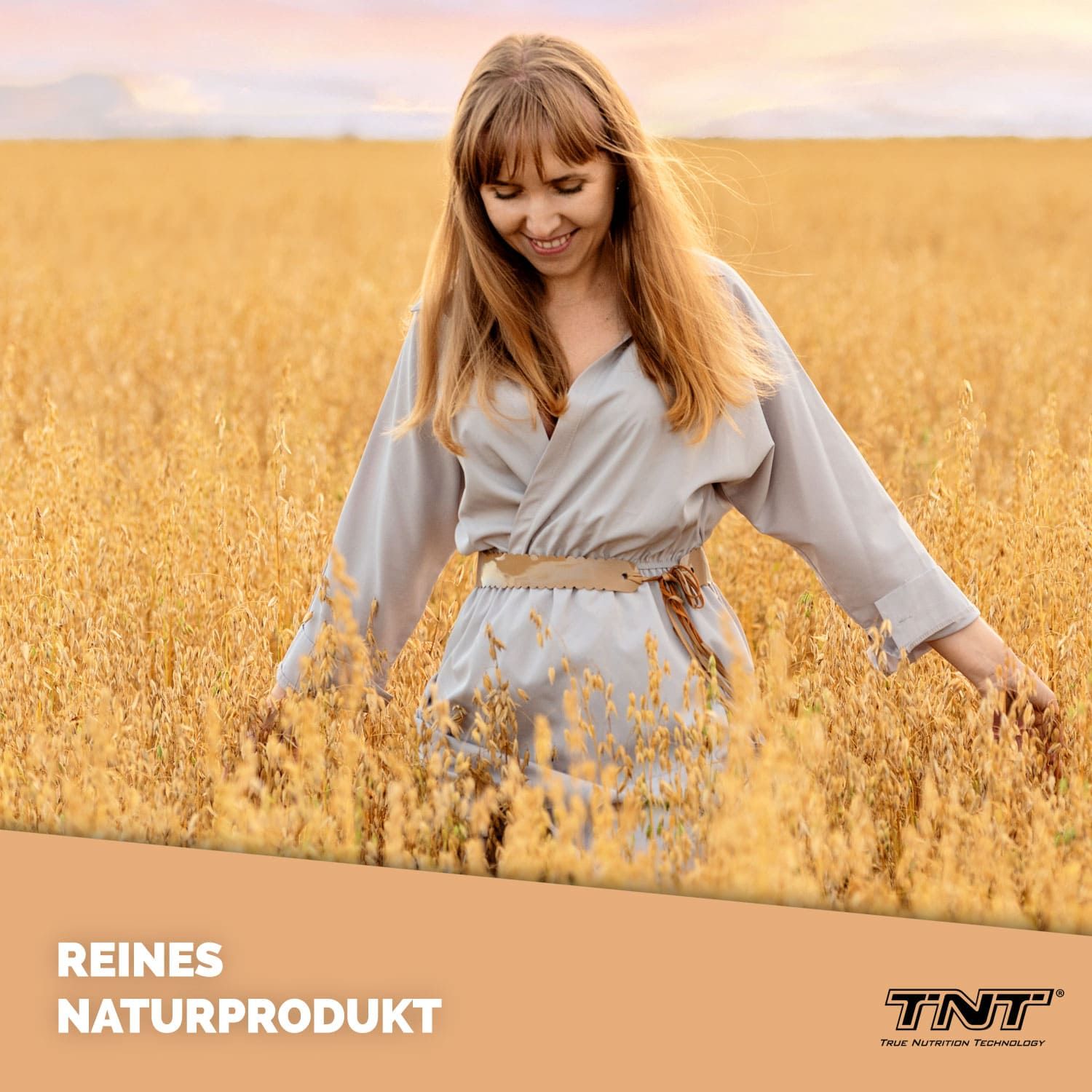 Frau in einem Feld. Text: Reines Naturprodukt. Marke: TNT. Frau berührt Getreide.
