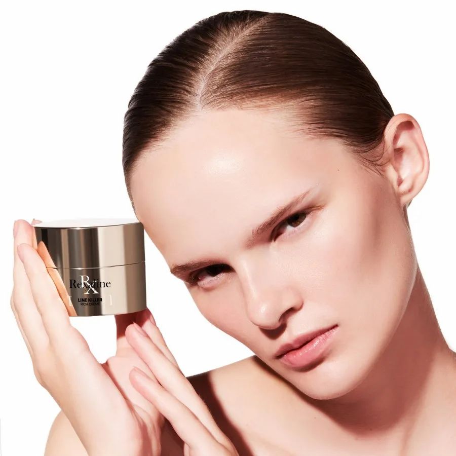 Frau hält einen Creme-Tiegel. Auf dem Tiegel steht Rexaline Line Killer Rich Creme.