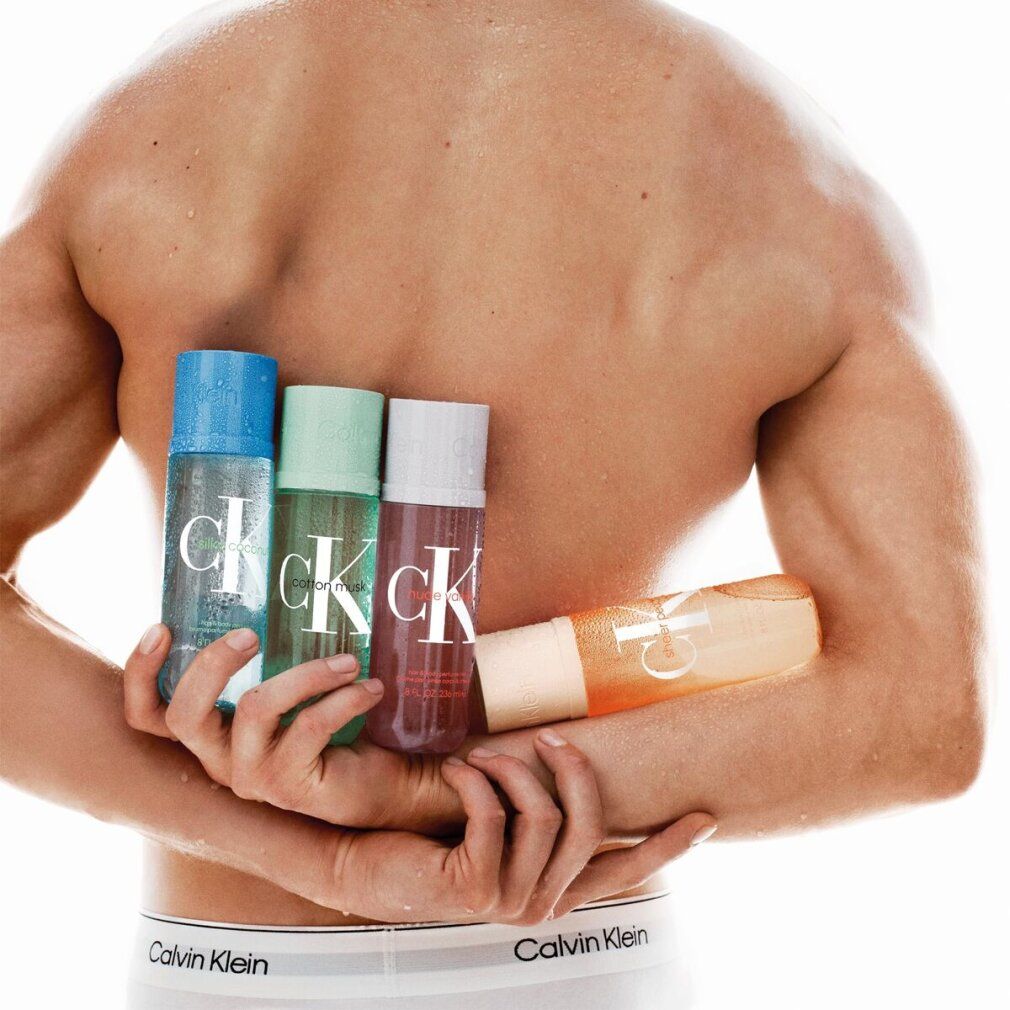 Mann hält vier Flaschen. Aufschrift "Calvin Klein". Flaschen in Blau, Grün, Weiß und Orange. Mann trägt Unterwäsche mit Logo.